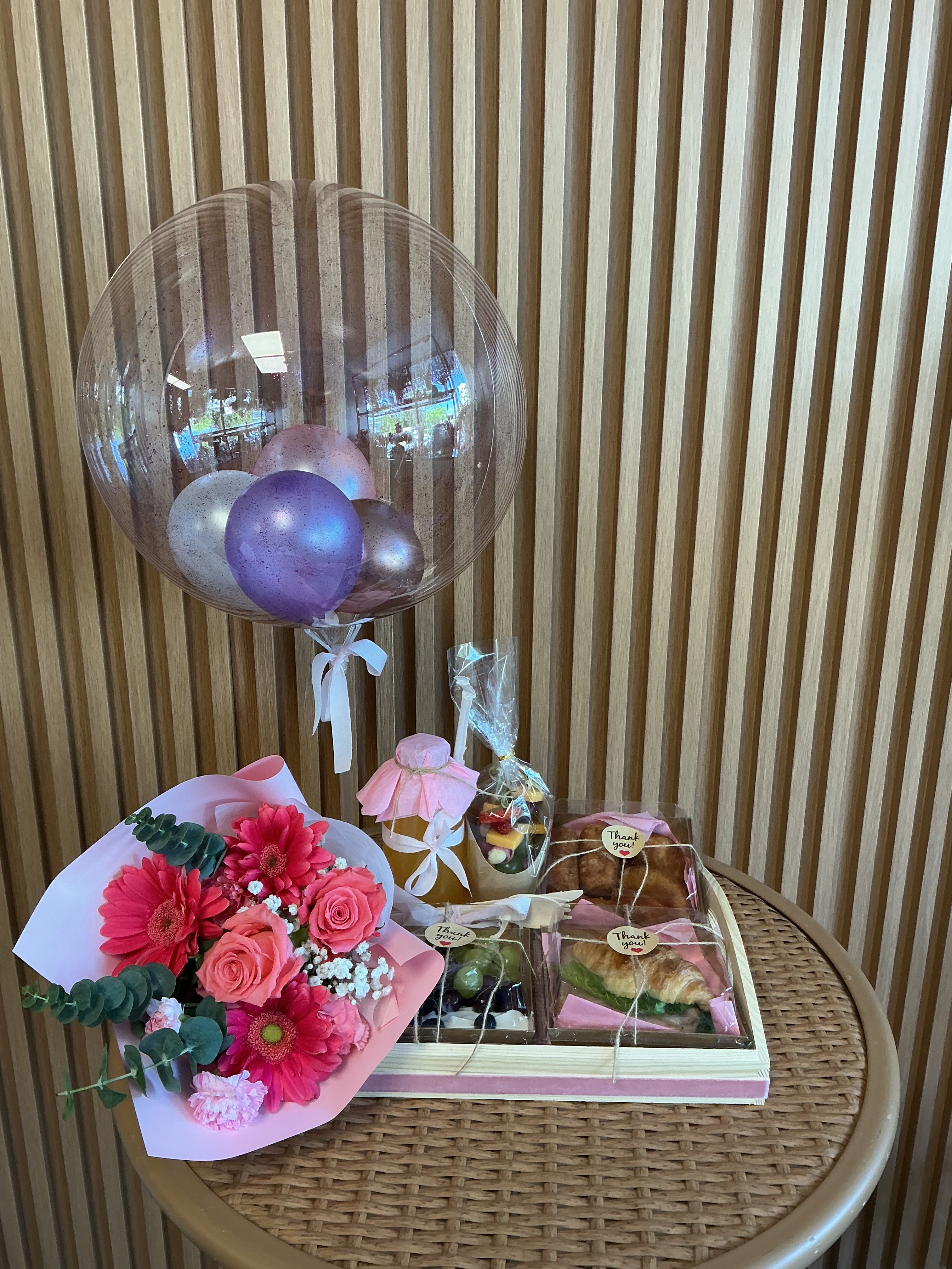 Esecencia para ella - delicioso desayuno sorpresa con saandwich de jamón y queso ,  tequenos , empanaditas , jugo de naranja natural , mix de frutas y un lindo bouquet floral.con un globo personalizado de cumpleaños o cualquier ocasión . Un detalle lleno de amor para alegrar su mañana. 