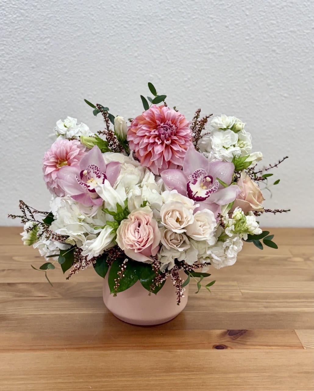 Pink and white floral arrangement in a blush vase