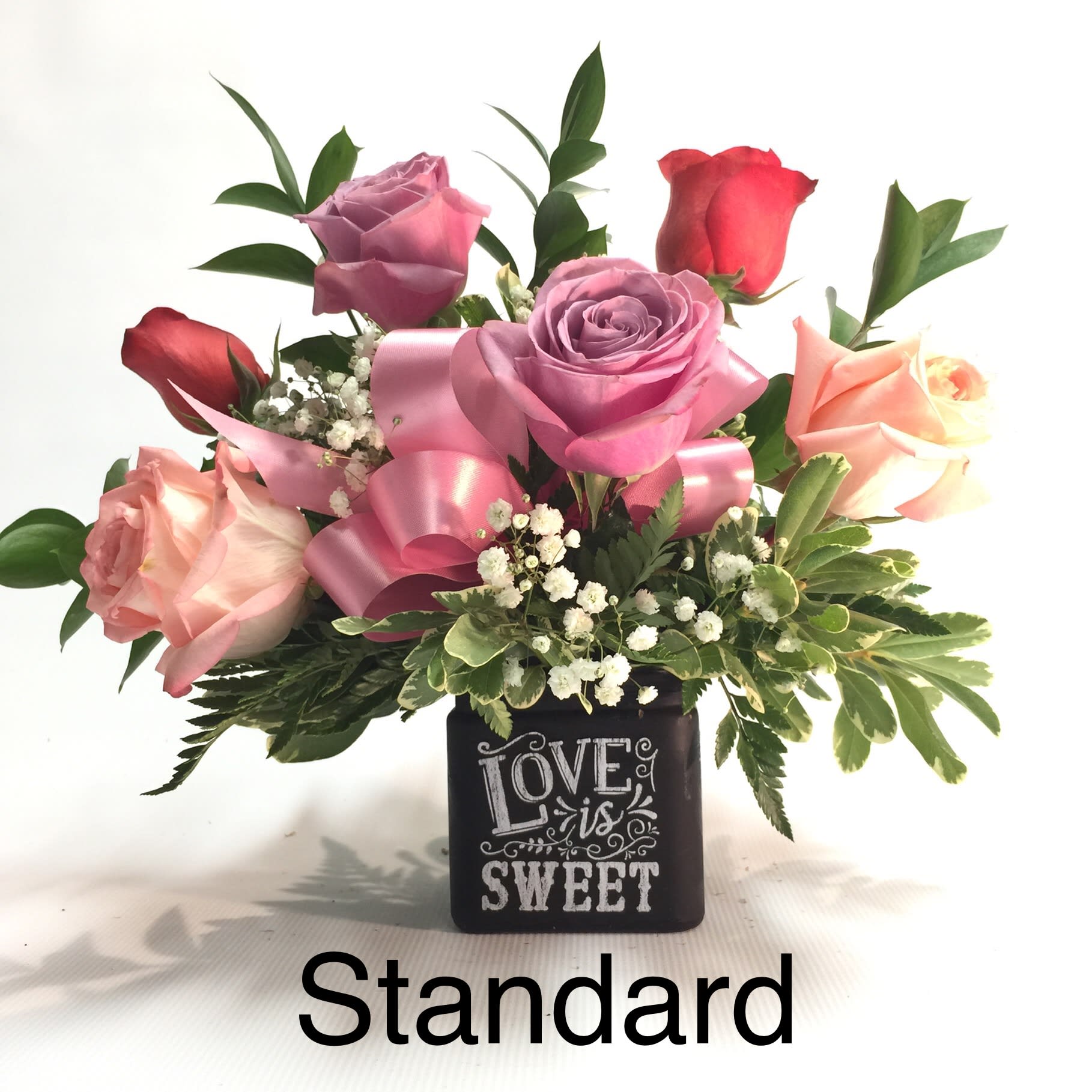 Pink and red roses in a black vase with a "Love is Sweet" design