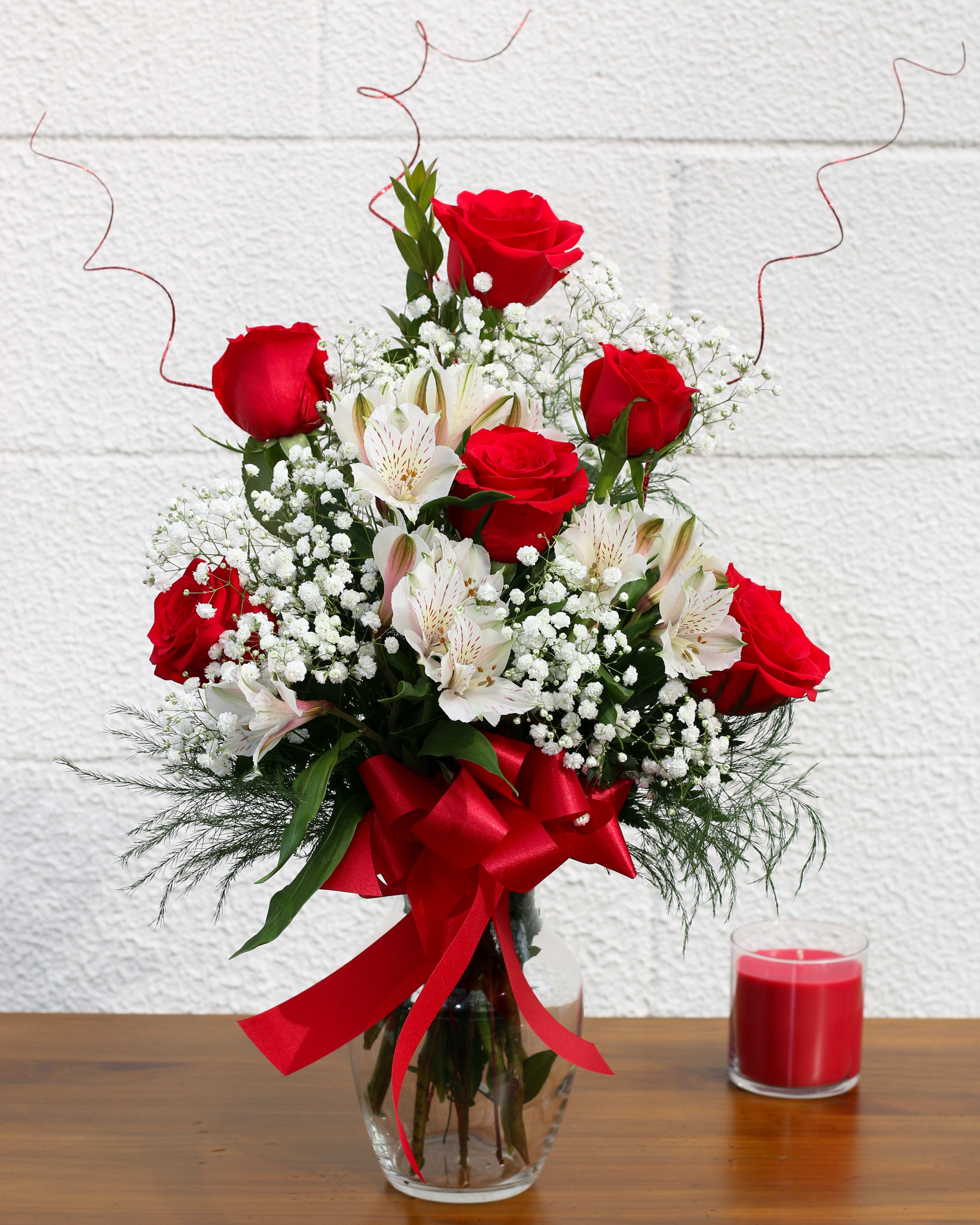 Roses &amp; Petite Lillies FG105 - Six premium long stemmed roses and several complimentary colored alstroemeria lillies arranged in a pretty vase and accented with a lovely bow and sparkling ting. Deluxe -- includes premium foliage. Premium -- includes premium foliage and premium accent flowers. Approximately 19" H and 14" W.