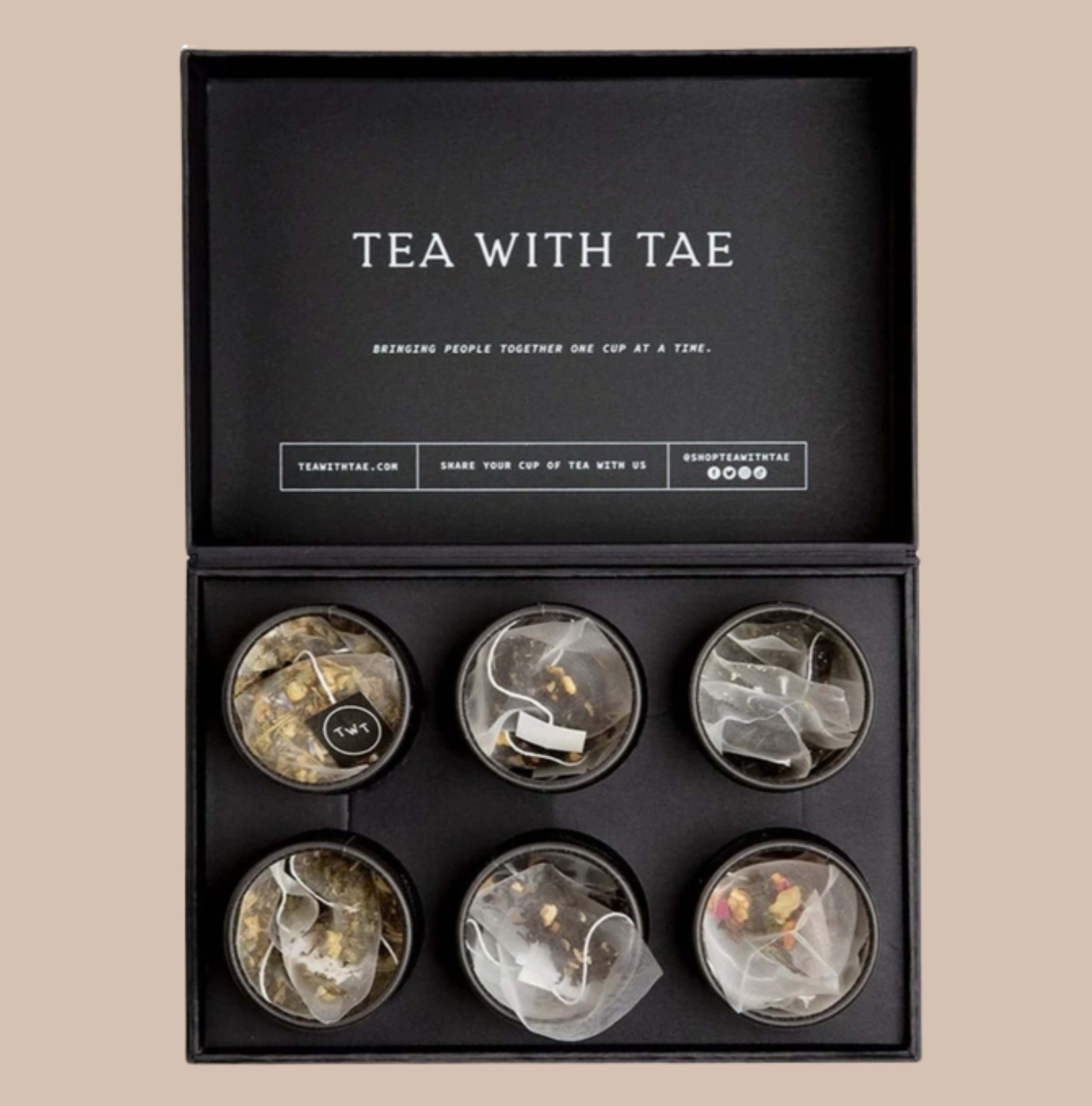 Tea with Tae  - A matte black presentation box of premium teas makes a calm, modern gift for housewarmings, hostess gifts, birthdays, or a thoughtful "thinking of you" moment. This tea gift set-presented like a contemporary bento box-reads as an intimate, wellness-focused present that helps the person you're thinking of slow down and savor a quiet cup.  Inside are six distinct tea varieties-English Breakfast, Garden Sunrise, Jasmine Green, Nighttime Routine, Peppermint, and Spa Bliss-each housed in small round tins or mini tea tubes with five pyramid sachets per tube (30 sachets total). The tins feature soft, muted label colors and sheer organza sachets visible over the leaves, all nested in a refined matte black box with simple white lettering and polished product labels and canisters for an elevated unboxing experience.  Perfect for gifting at weddings, anniversaries, holidays, or everyday moments, this set suits anyone who appreciates tea and self-care. Sized to share or keep on hand for daily rituals, it arrives ready to gift in its packaging box; no special care is required beyond storing in a cool, dry place.