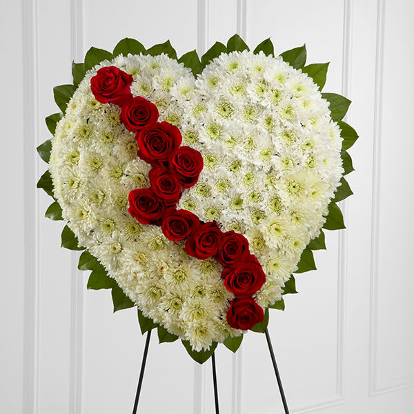 Broken Heart(FTD) - The FTD® Broken Heart™ is a beautiful way to express the impact that the departed had on your life. Pearly white chrsyanthemums form the shape of a heart accented with greens lined around the outside and "broken" in the middle with a line of rich red roses to create an exqusite way to honor the life of the deceased at their memorial service. Displayed on a wire easel.