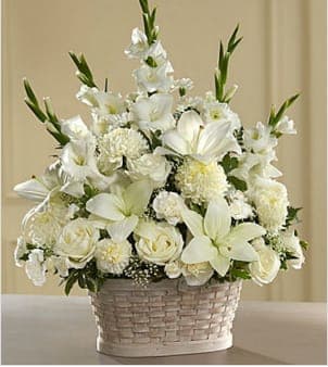 The FTD® Peaceful Passage™ Arrangement - Let this exquisite bouquet deliver your sincere condolences at this time of loss and sadness. An always-appropriate mixed bouquet of white roses, carnations, gladioli, football chrysanthemums, LA hybrid lilies, and million star gypsophelia plus an assortment of lush greens comes hand-arranged in a charming white wood chip basket by a local FTD artisan florist. This versatile arrangement is perfect for display on a table, floor or pedestal at a funeral home, on an altar, floor or sanctuary steps for a funeral, and graveside at a burial ceremony.  Your purchase includes a complimentary personalized gift message.