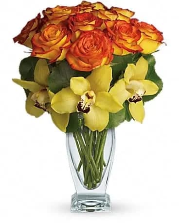 Aloha Sunset - Aloha is a celebration of joy, gratitude and being in the present. Lovely orchids celebrate the spirit of aloha, especially when mixed with gorgeous roses evocative of a Hawaiian sunset. This stunning arrangement has it all. Beautiful yellow cymbidium orchids, brilliant bi-color roses and tropical leaves all hand-delivered in a striking Couture Vase. It's definitely a departure from the everyday! 