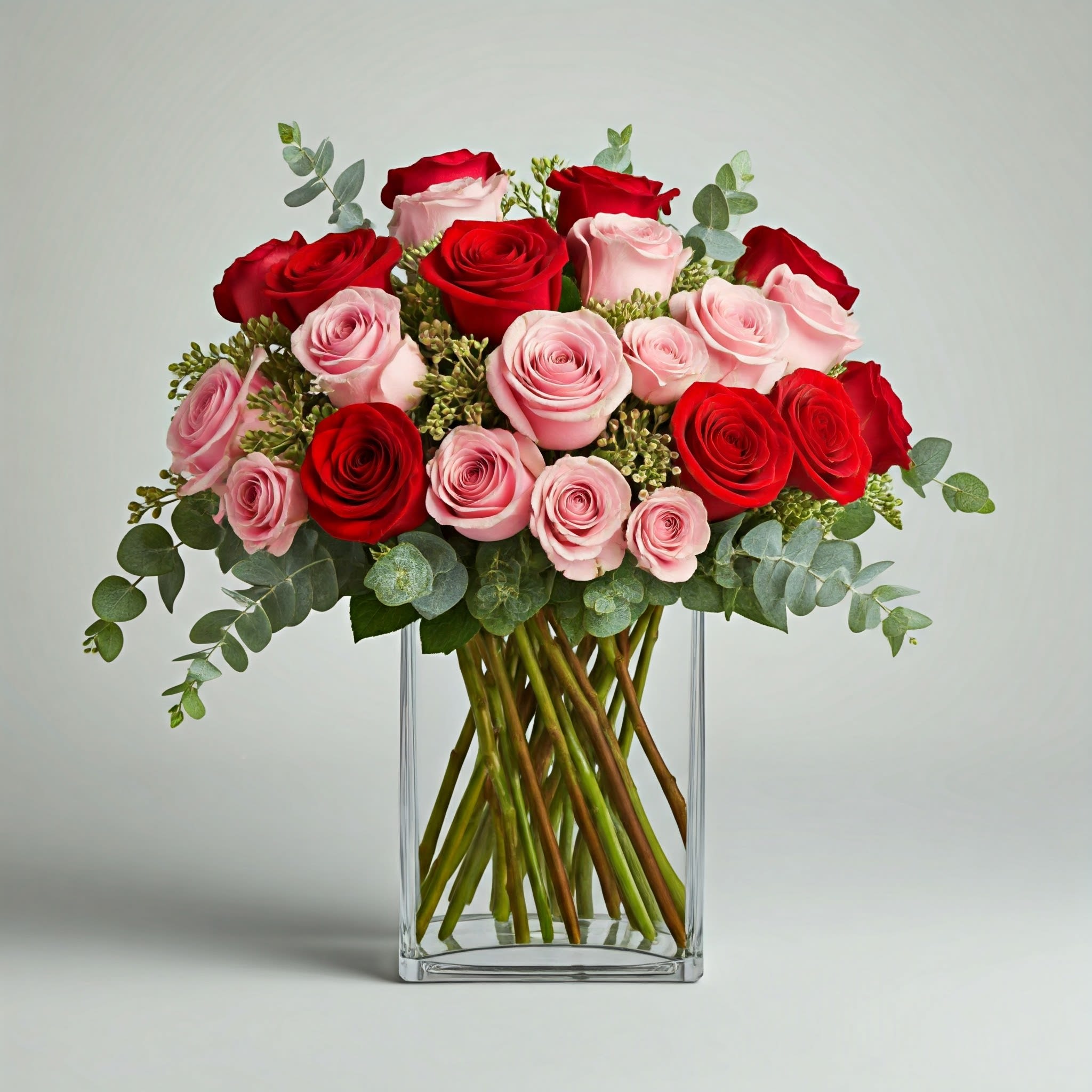 Bouquet of red and pink roses in a clear glass vase