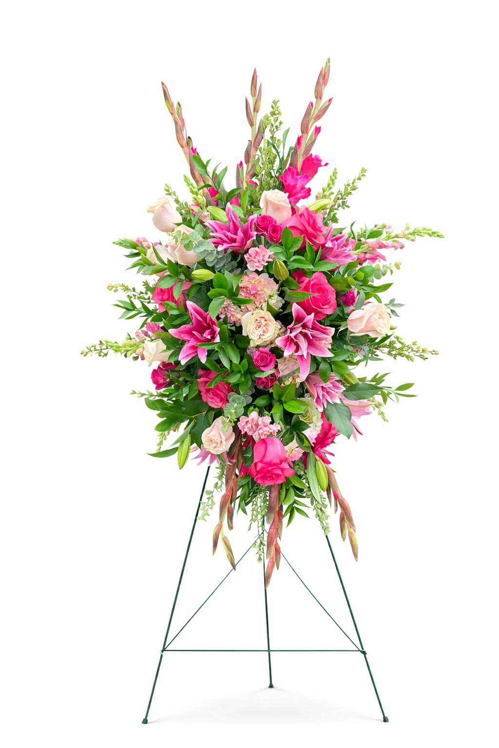 Blushing Garden Standing Spray - A graceful expression of love, remembrance, and heartfelt sympathy.  This lush standing spray features a vibrant blend of pink stargazer lilies, roses, gladiolus, and seasonal accent blooms, thoughtfully designed with cascading greenery for movement and dimension. Arranged on an easel, this piece makes a beautiful and meaningful tribute for services, memorials, or celebrations of life.  Soft blush tones paired with bold pink florals create a design that feels both comforting and uplifting—honoring a life beautifully lived while offering warmth to those left behind.  Details: 	•	Designed on a standing easel 	•	Features premium seasonal blooms in shades of pink and blush 	•	Size: Approx. 48” tall 	•	Suitable for funeral services, memorials, and celebrations of life  Flowers may vary slightly based on seasonal availability, but the overall color palette and design style will be maintained.