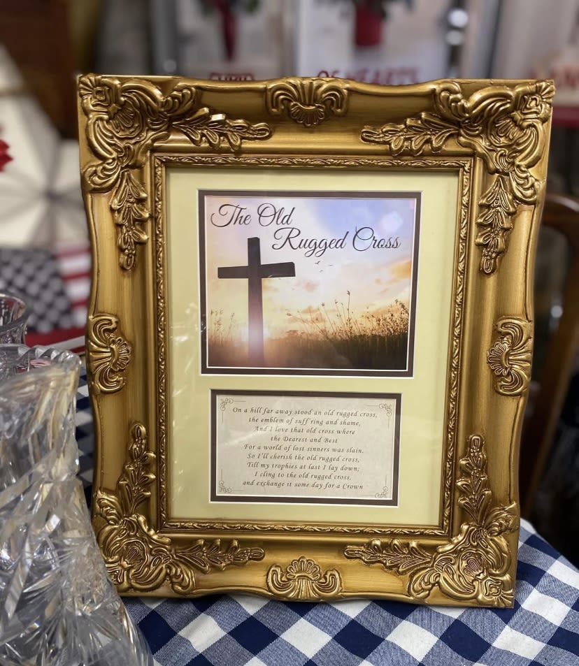 Old Rugged Cross Tabletop Picture - A warm, devotional tabletop gift that brings quiet reflection to a mantel or memorial space - the Old Rugged Cross tabletop picture is a framed religious print suited for sympathy, remembrance, or personal devotion. The ornate gold picture frame and the printed artwork make this an appropriate keepsake for a funeral home display, a remembrance corner, or a thoughtful sympathy gift to let someone know you're holding them in your prayers.  The heavy carved frame features raised floral scrollwork and a rich metallic finish that catches light against the print's soft sunrise sky and dark cross motif. Sized for tabletops, the piece reads as a traditional, reverent accent in yellow, white, and black tones; it's ready to place where the person you're thinking of will see it daily and feel comforted by the devotional image and classic framing.