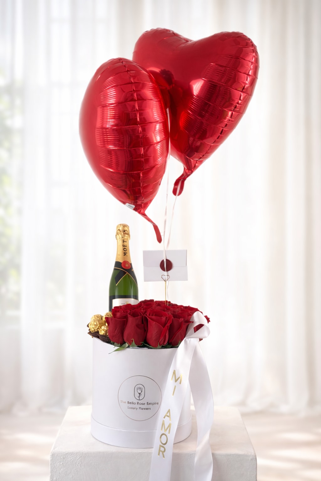 Box Celebrate  - A satin-finish box accompanied by export-quality red roses, Ferrero Rocher, a bottle of Moët &amp; Chandon, and two helium balloons featuring a delicate satin ribbon placed to the side with a short message.