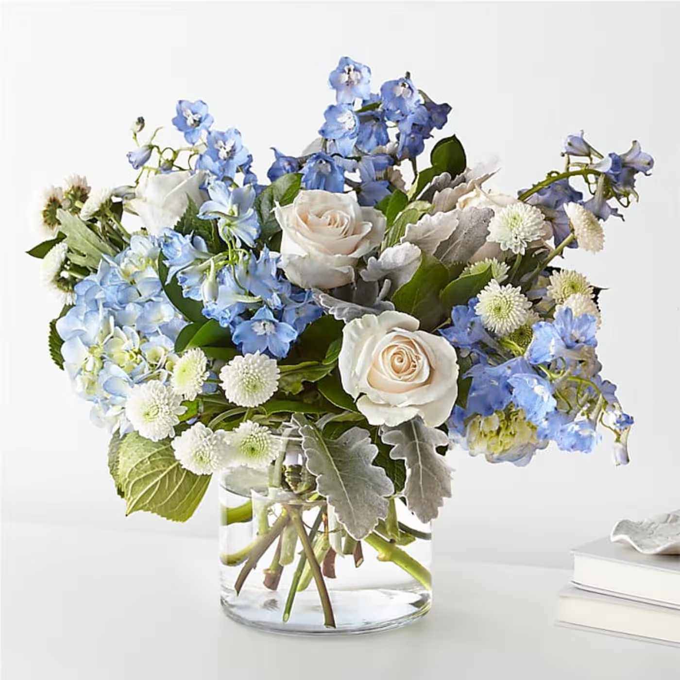 Blue and White Ice - Introducing our enchanting Blue and White Ice Flower arrangement, where nature's elegance meets cool sophistication. This mesmerizing bouquet features a delicate blend of pristine white blooms and striking blue petals, creating a harmonious dance of colors reminiscent of a winter wonderland.