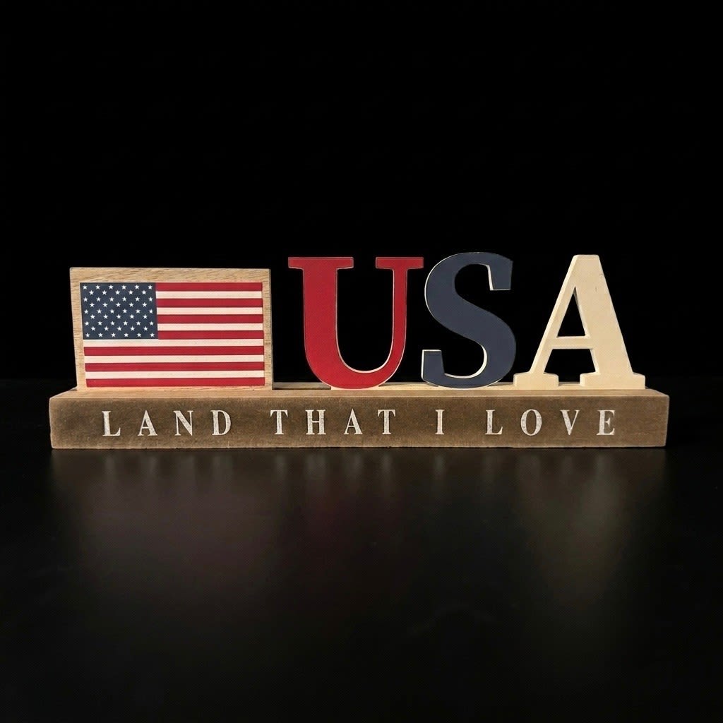 Americana Block "Land that I Love" Tabletop Decor - Add a charming patriotic accent to your home with this "USA" block sign. Featuring a natural wood base stenciled with "Land That I Love," this freestanding piece beautifully displays a mini American flag alongside crisp red, white, and blue block lettering. Perfectly sized for cozy spaces, it makes a sturdy, eye-catching shelf sitter for tiered trays, entry tables, mantels, or kitchen counters. A lovely addition to your seasonal Fourth of July or year-round Americana decor  Dimensions 11.5" W 3.75" H 2" D