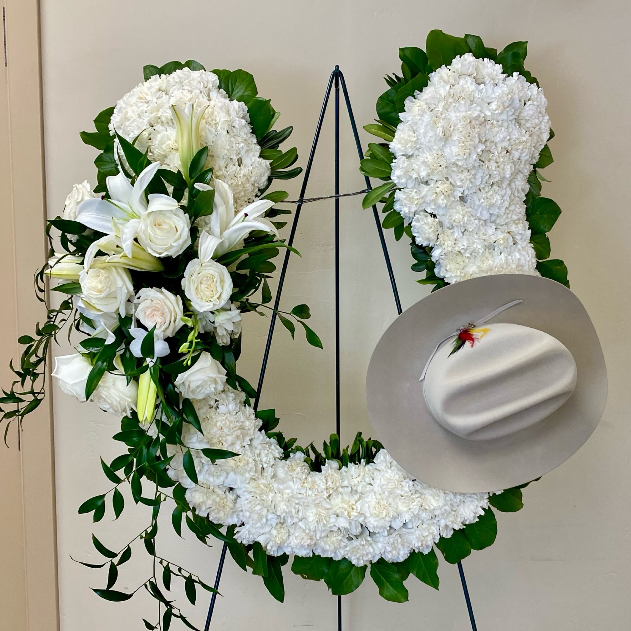 Horse Shoe Wreath - This Horseshoe Wreath Includes White Carnations, White Lilies, White Roses, White Dendrobium Orchids and Greens. HAT IS NOT INCLUDED. OPTIONAL: We can attach your loved one's hat if it's dropped off in advance. Or as Similar as Possible.  