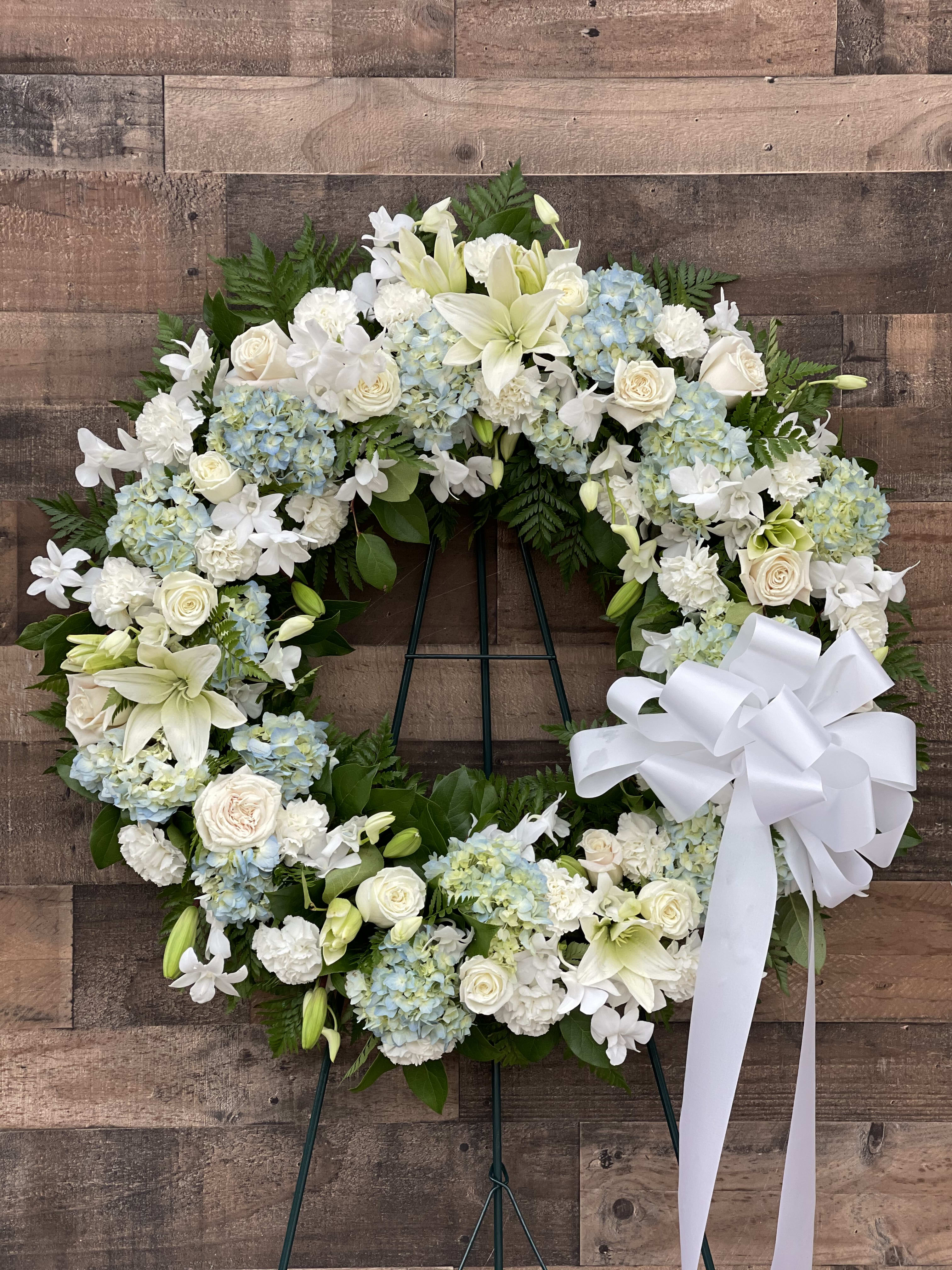 White and pale blue floral wreath with a large white bow