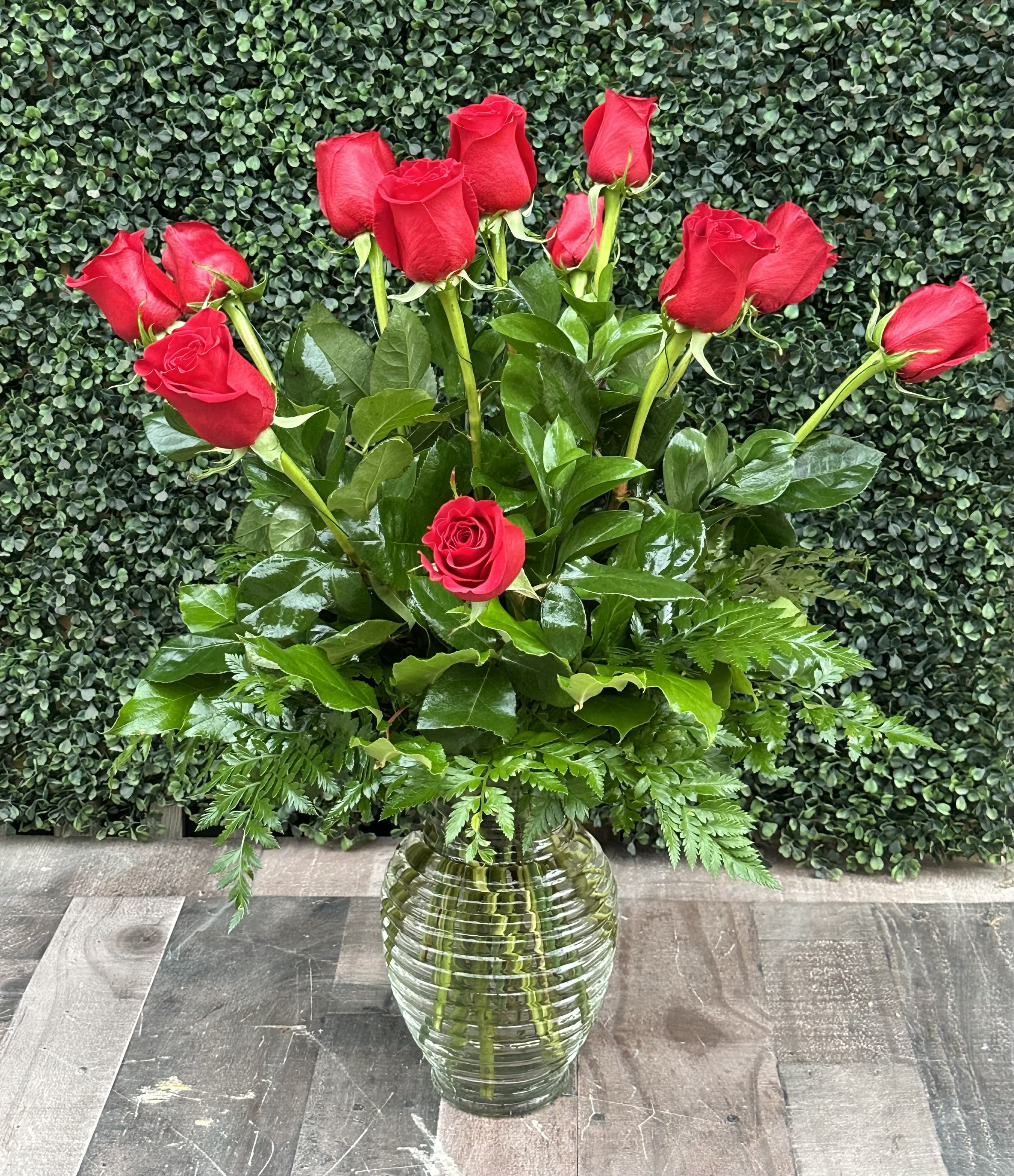 Red roses arranged in a clear glass vase