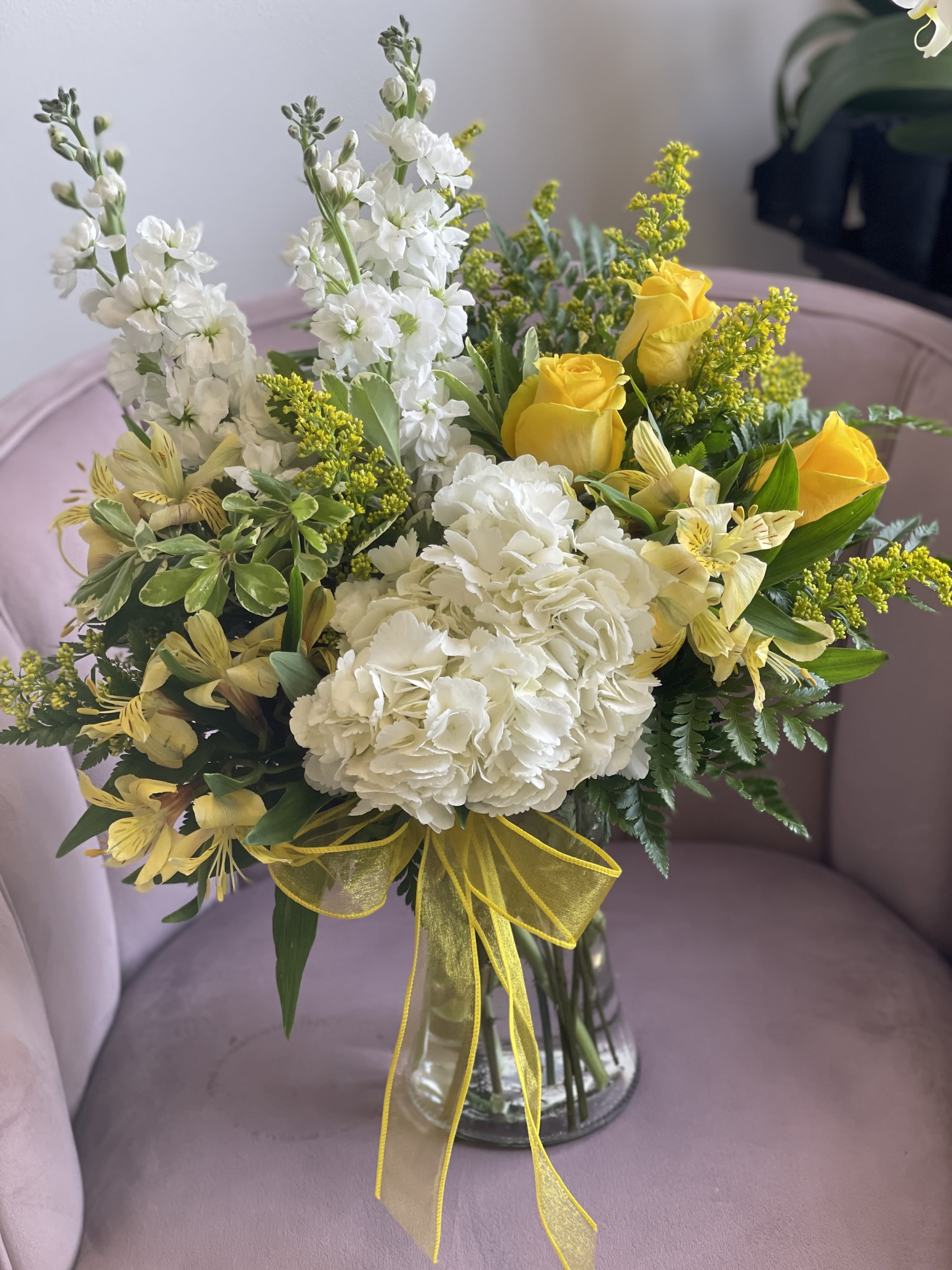 Bouquet of white and yellow flowers in a clear glass vase