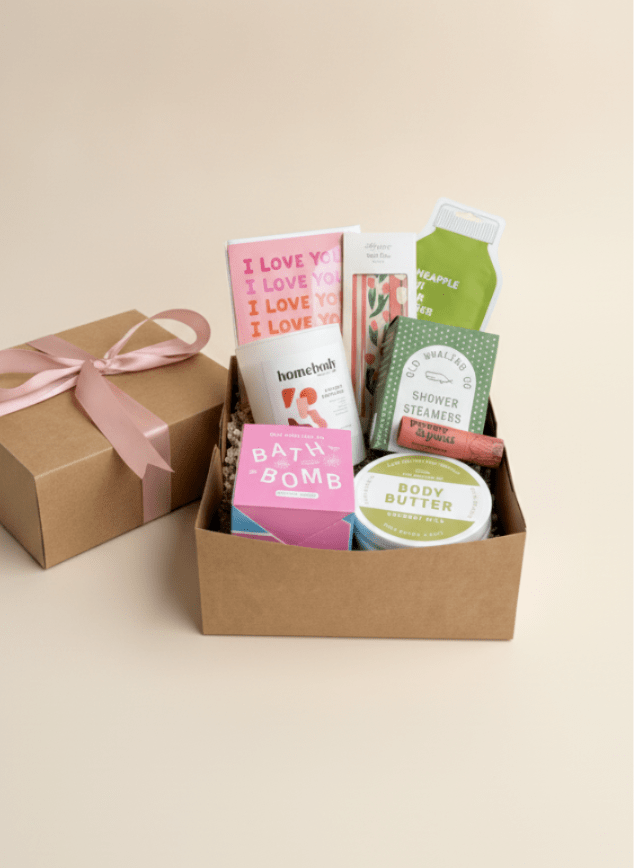 Gift box with bath and body products and a pink ribbon-tied box