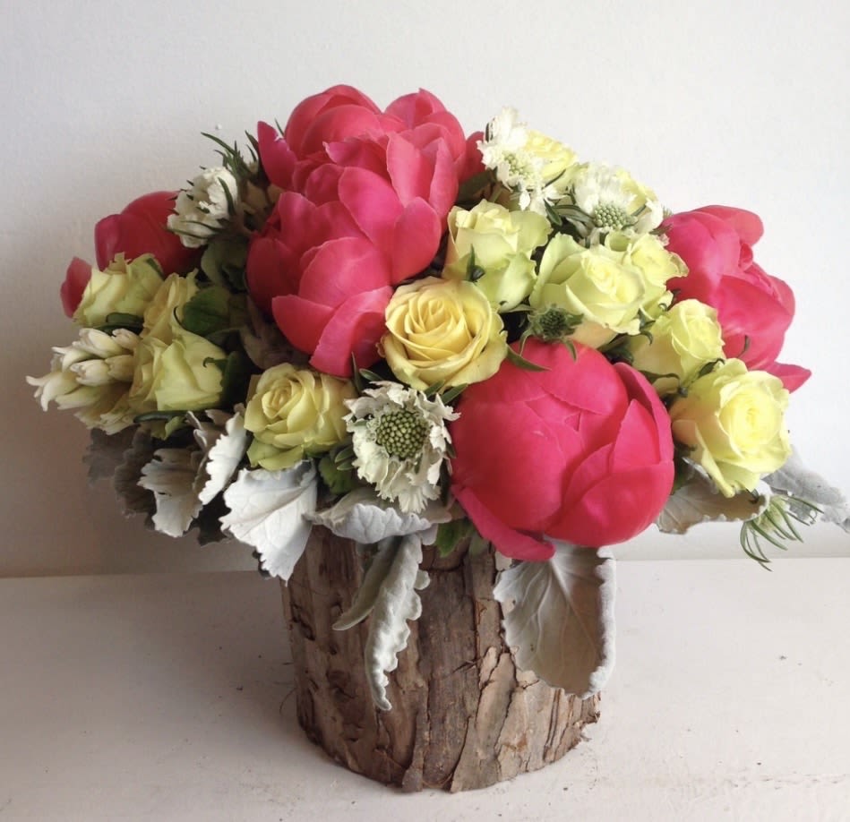 SUNSET CRUISE - These peonies we are seeing right now are so gorgeous. We designed them with yellow roses and white scabiosa in a very cute round wooden container.  