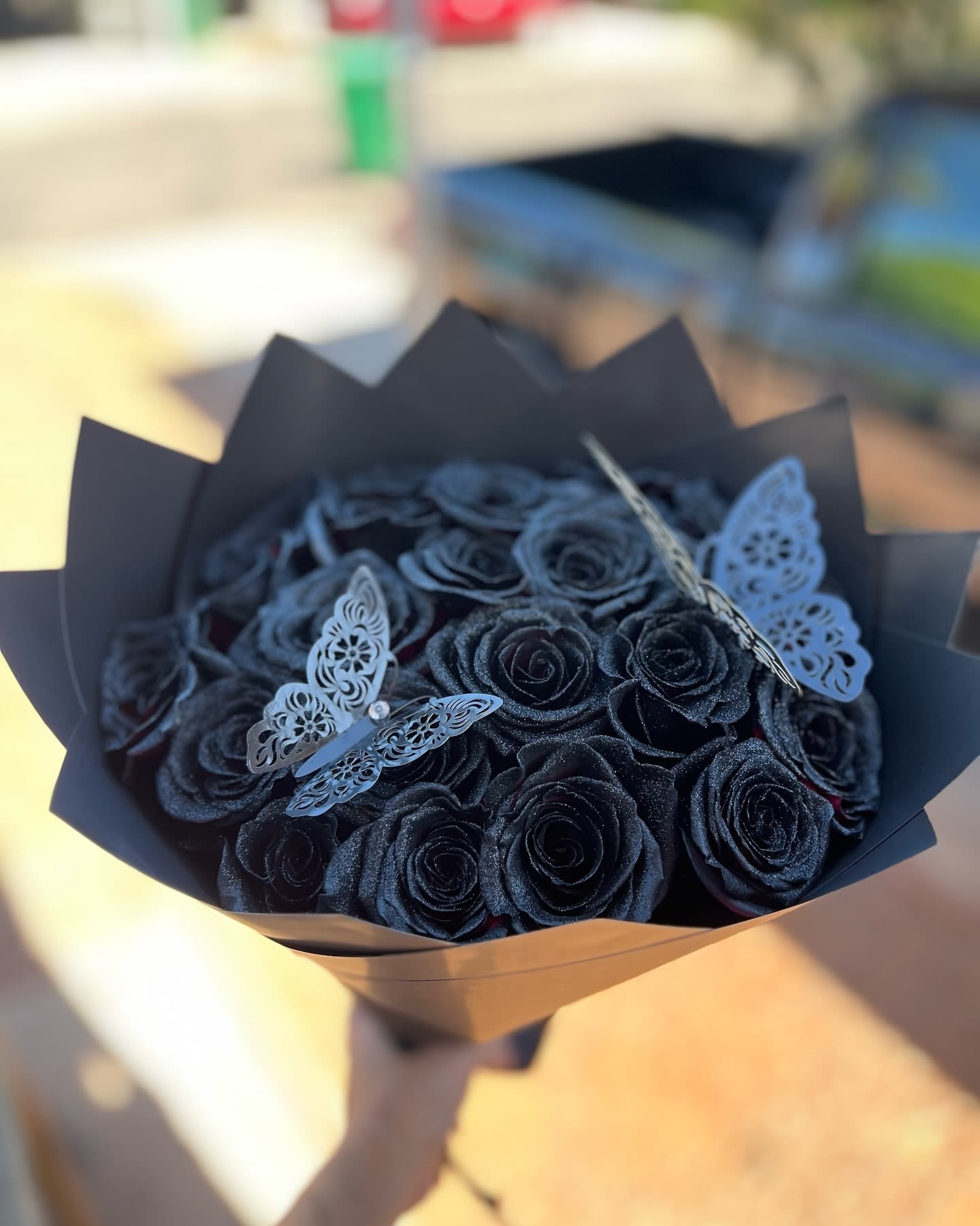 Bouquet of black roses with decorative butterfly accents