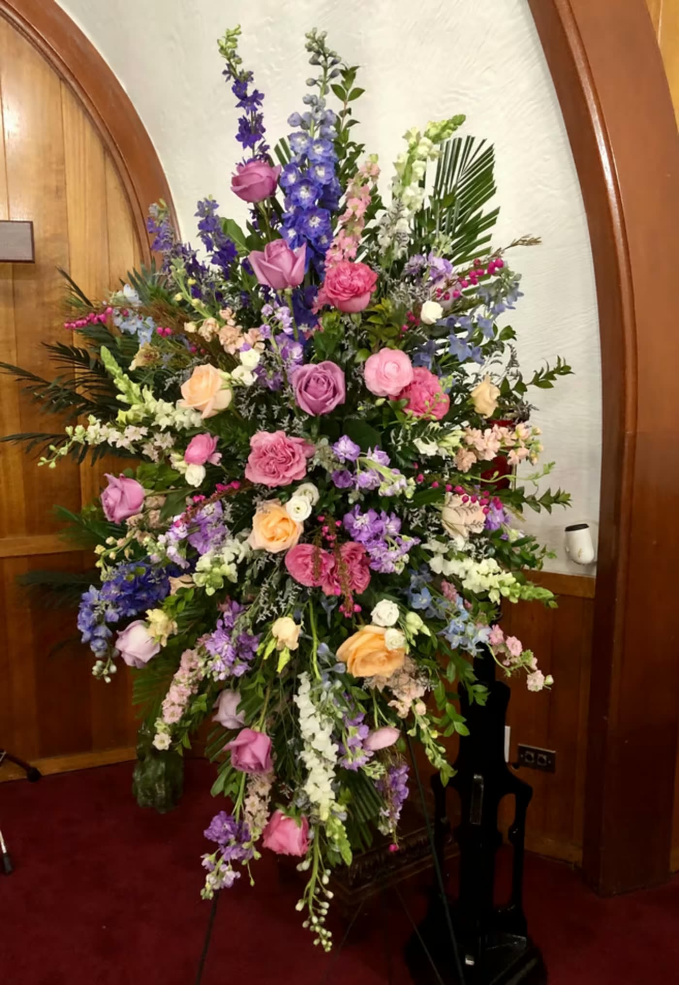 Large standing floral spray with pink, purple, and white flowers