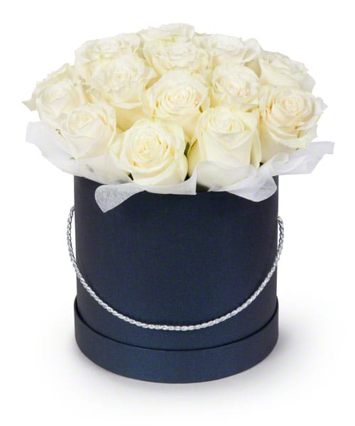 White roses arranged in a black round hat box