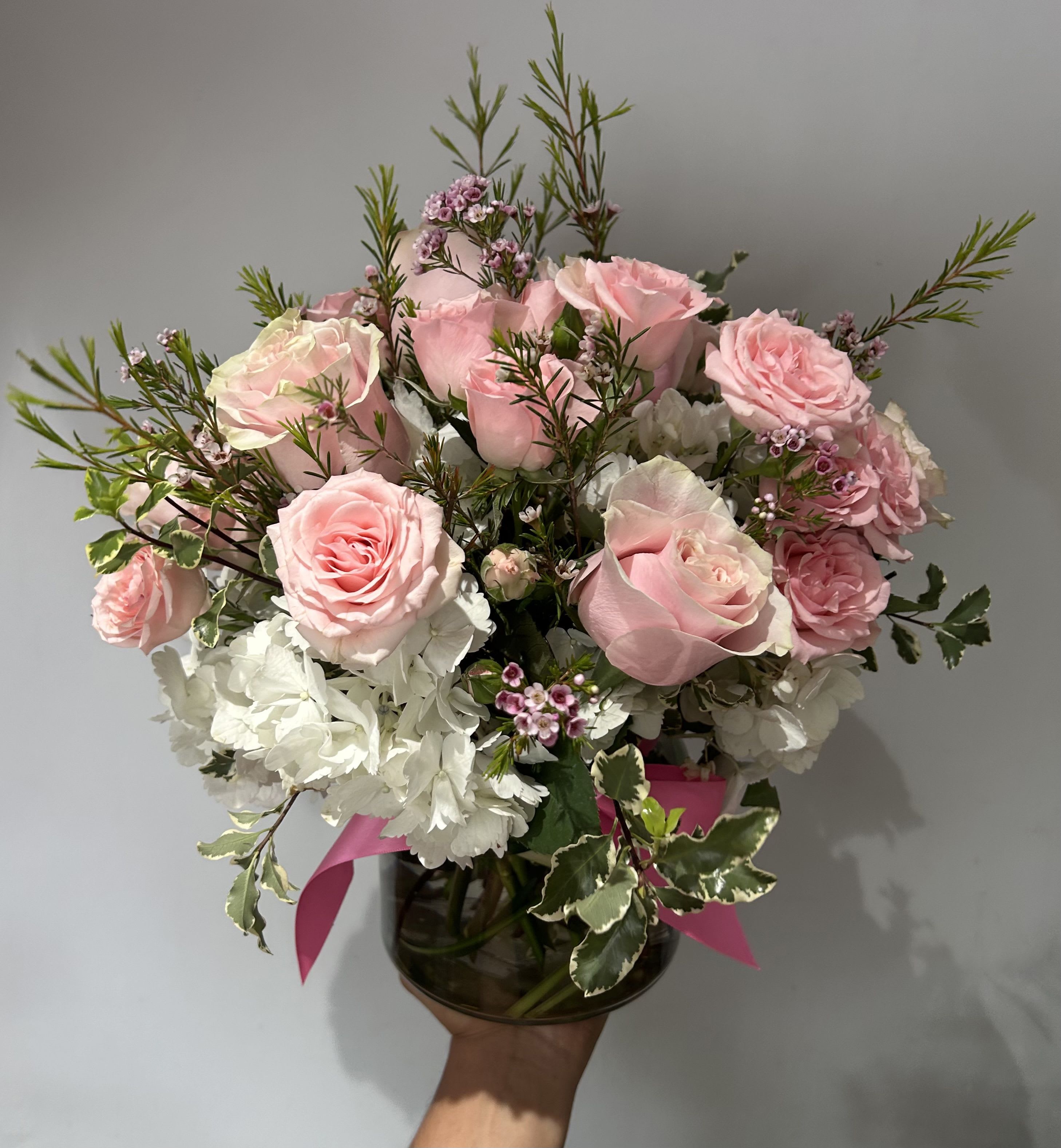 Lovely Pink - Light pink roses and spray roses arranged into a vase with hydrangeas, fillers and greens. 