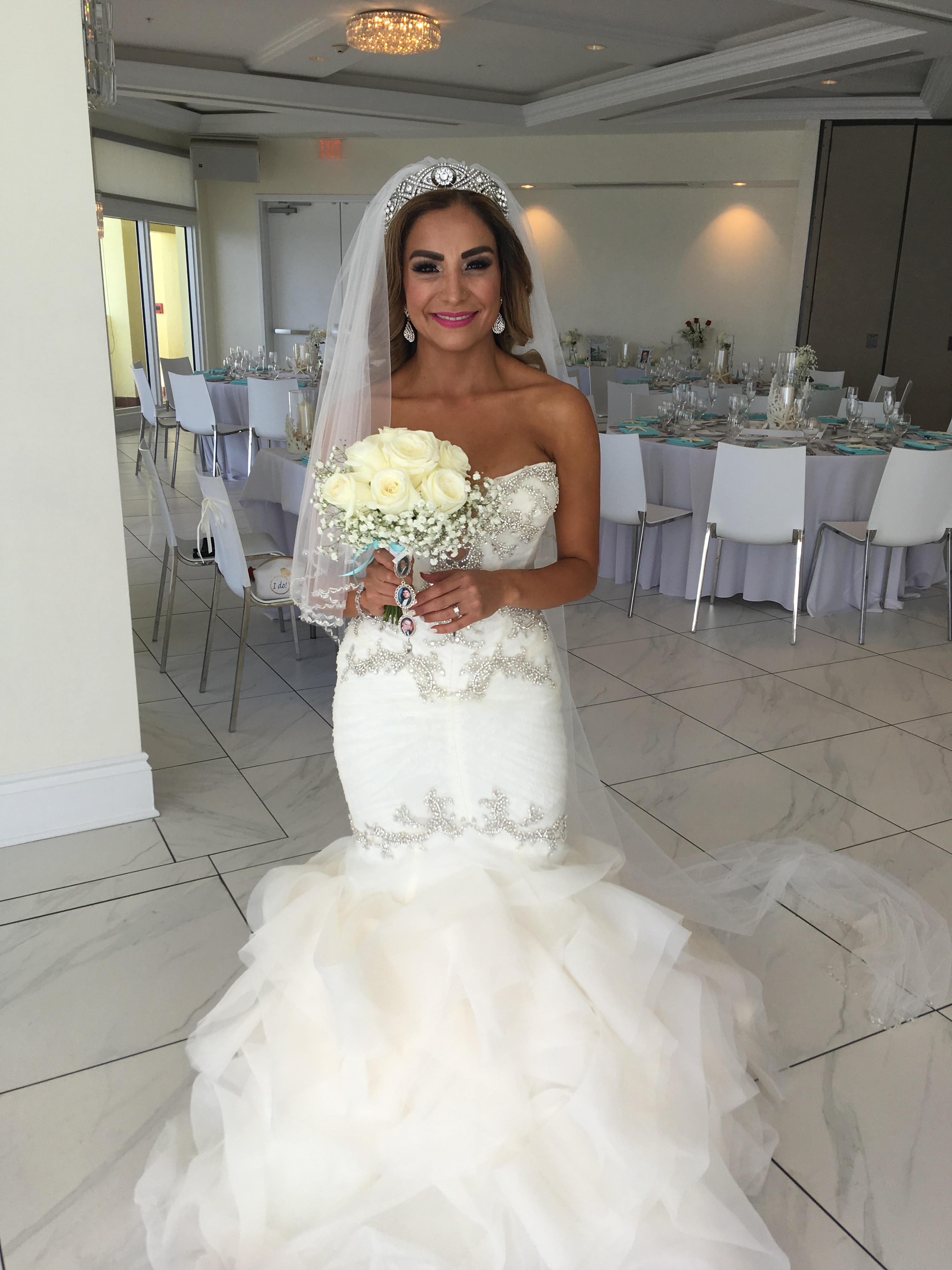 Bride holding a bouquet of white roses at a wedding reception