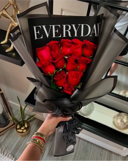 Bouquet of red roses wrapped in black and gray paper