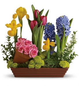 Mixed bouquet with pink roses, tulips, irises, and hyacinths in a rectangular planter