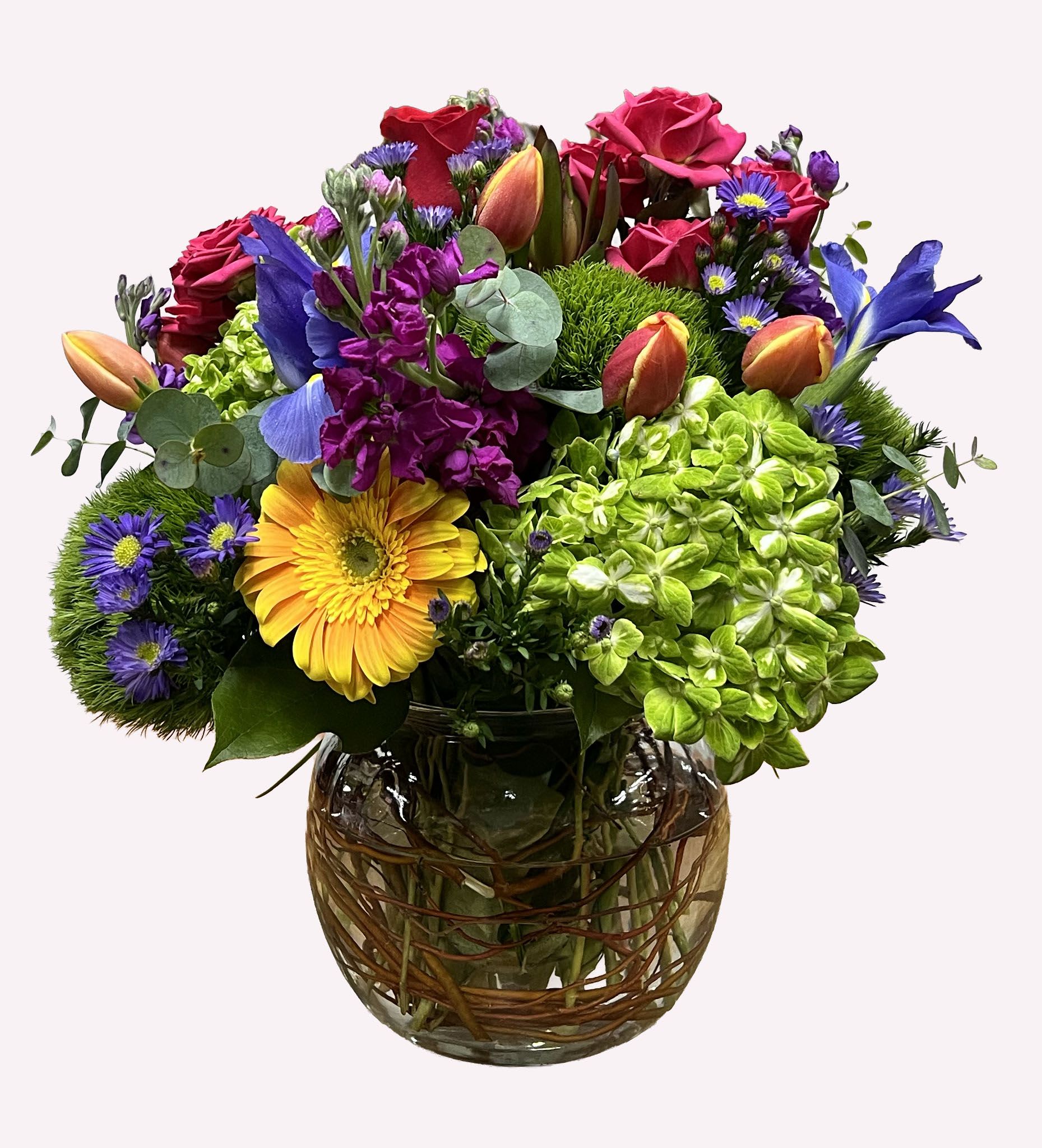 Mixed bouquet of roses, hydrangea, and daisies in a glass vase