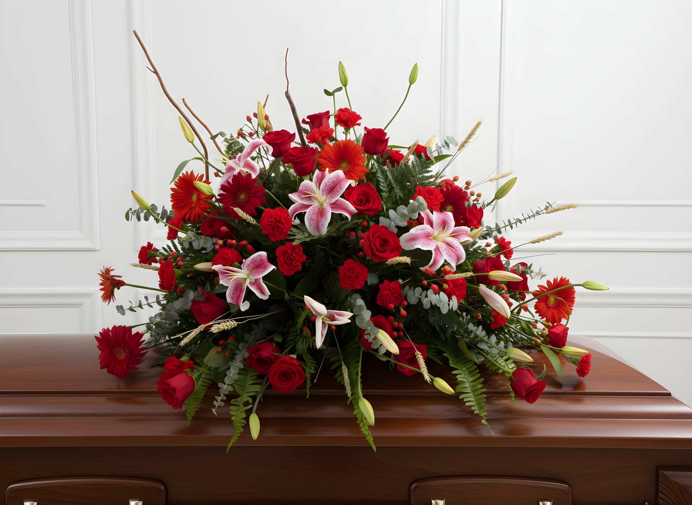 Large red and pink floral spray on a casket