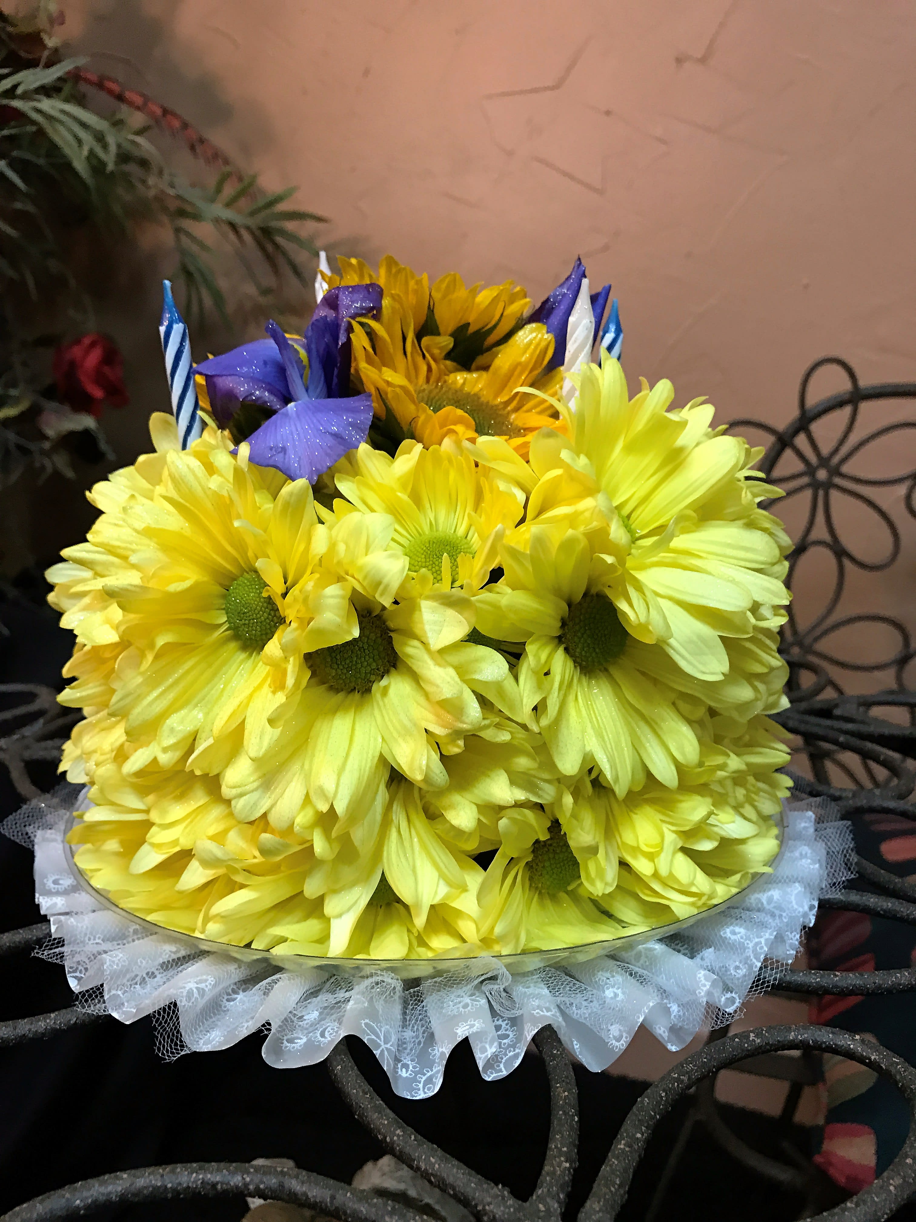 Yellow daisy bouquet with purple accents and striped candles