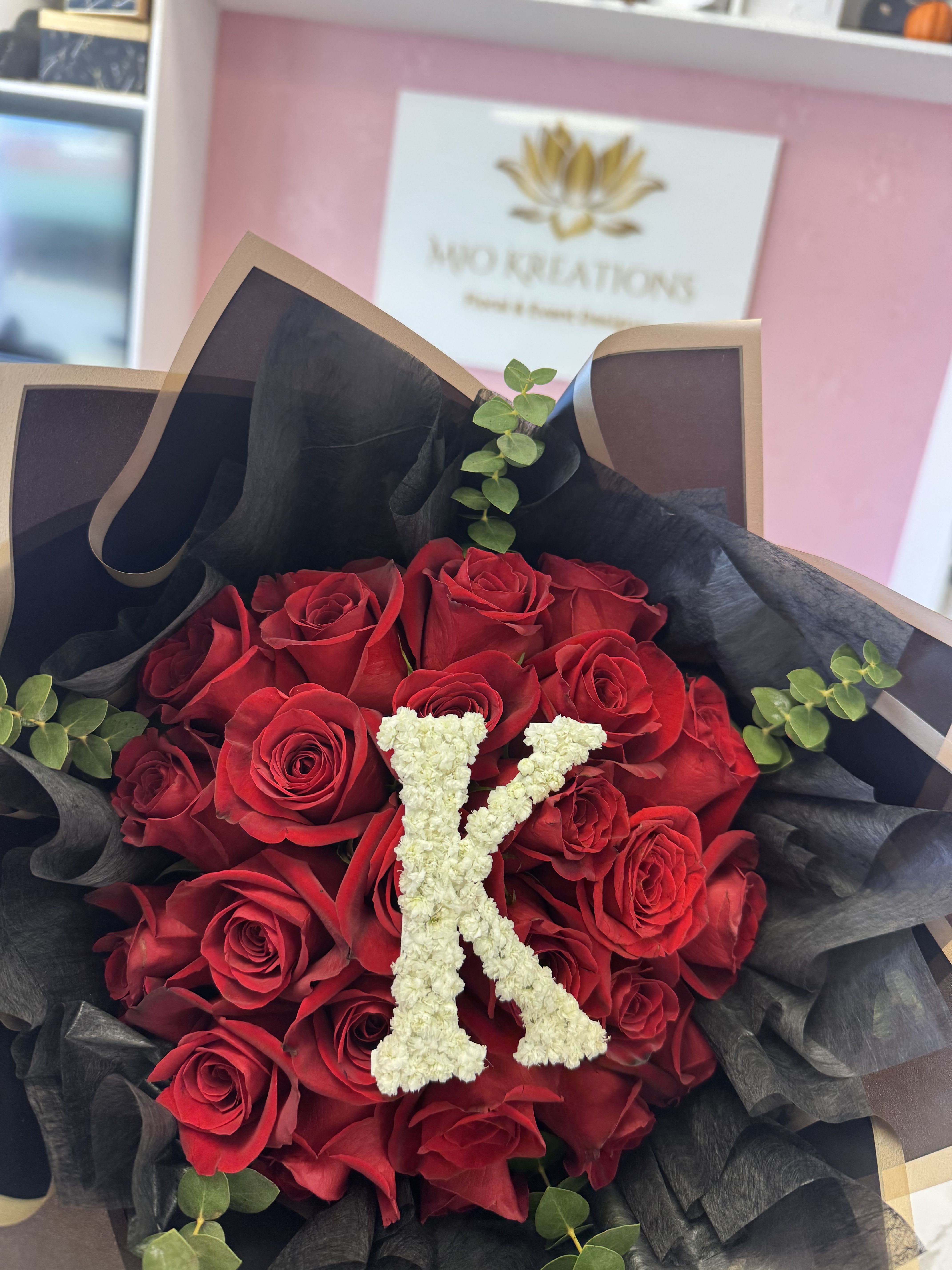 Bouquet of red roses with a white floral letter K