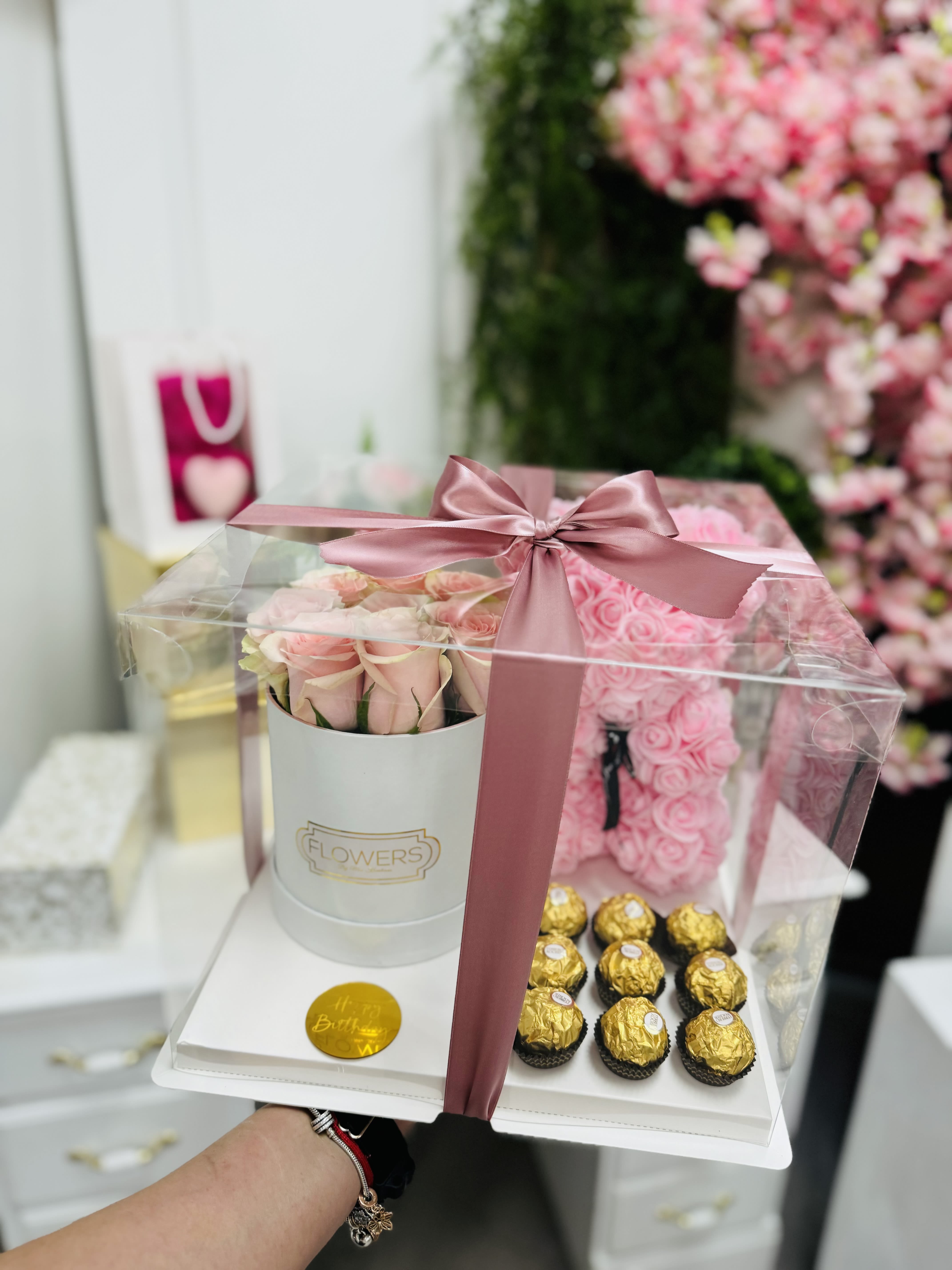 Pink roses in a gift box with chocolates under a clear cover