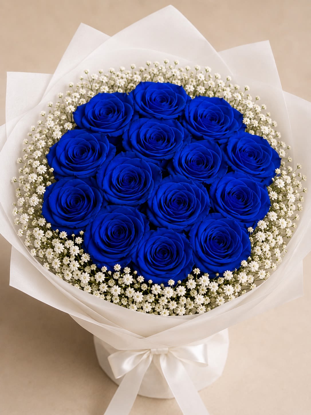 Royal Blue Devotions - Make a bold and unforgettable statement with Royal Blue Devotion, a luxurious bouquet featuring stunning blue roses accented with delicate baby’s breath for a timeless and elegant presentation. The rich blue blooms symbolize admiration, loyalty, trust, and appreciation, creating a meaningful gift for life’s most important moments.  Designed with a full, lush appearance and complemented by soft white accents, this bouquet offers a sophisticated balance of beauty and elegance. Whether celebrating Father’s Day, a birthday, an achievement, or simply expressing gratitude, Royal Blue Devotion is a striking arrangement that leaves a lasting impression.