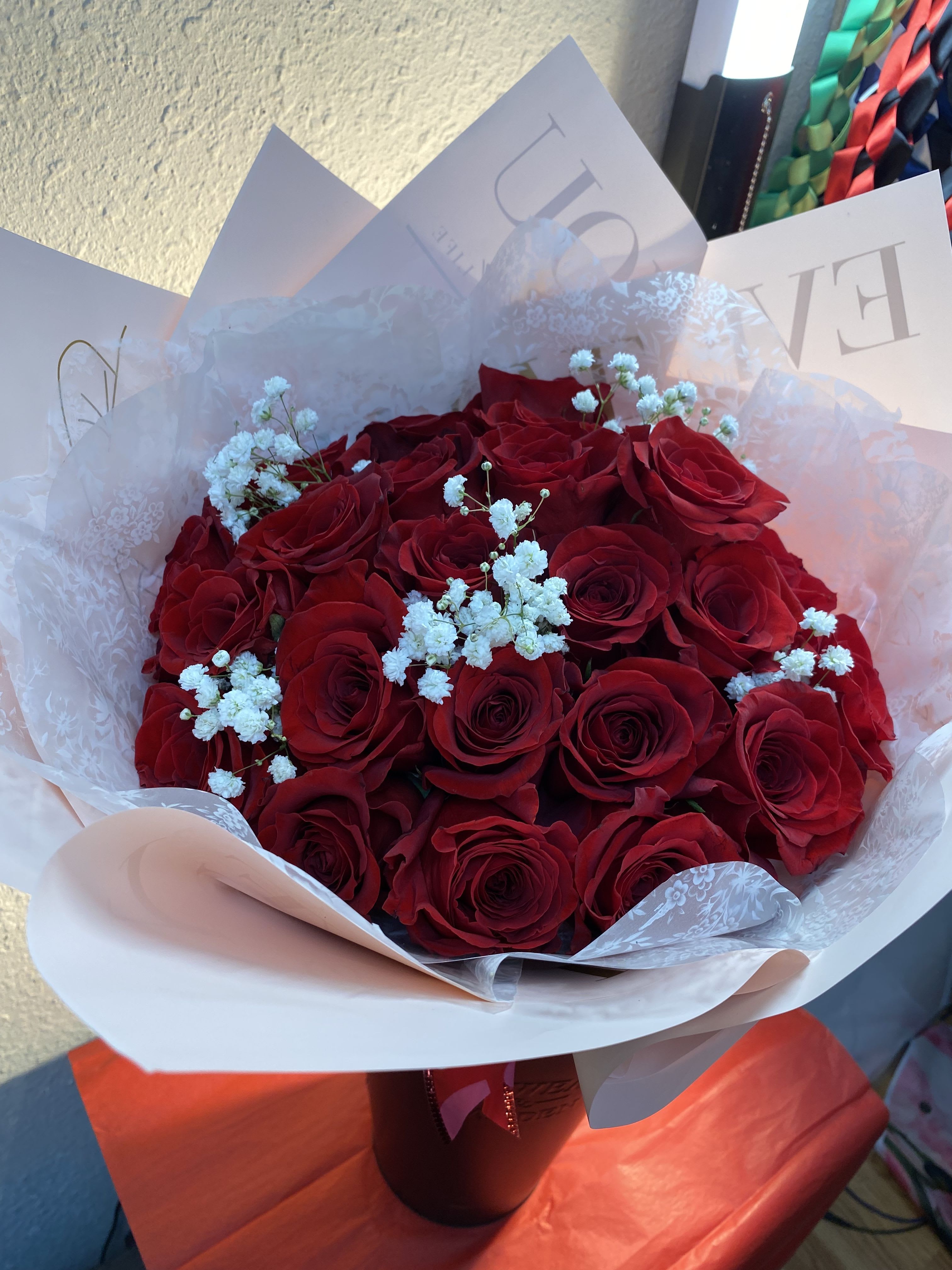 Bouquet of red roses with white baby's breath in white wrapping