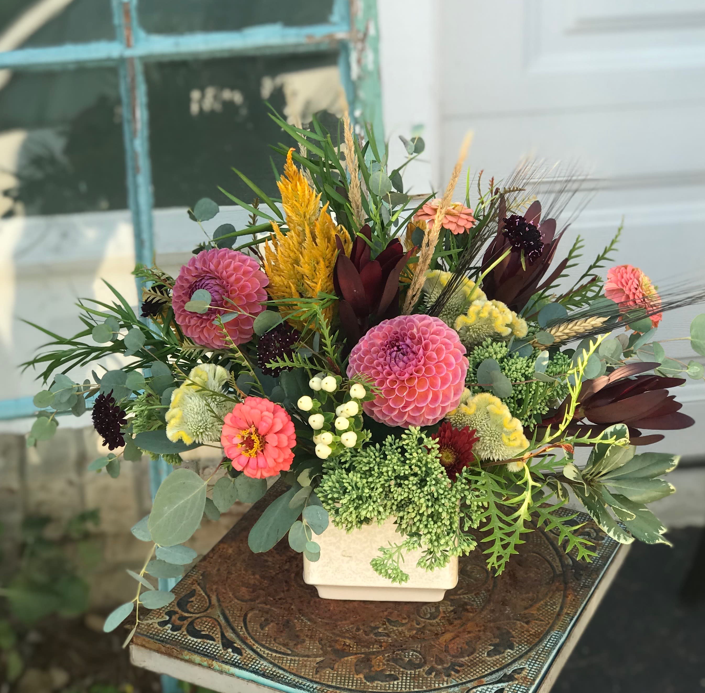 Mixed bouquet in a white square vase with pink and coral blooms