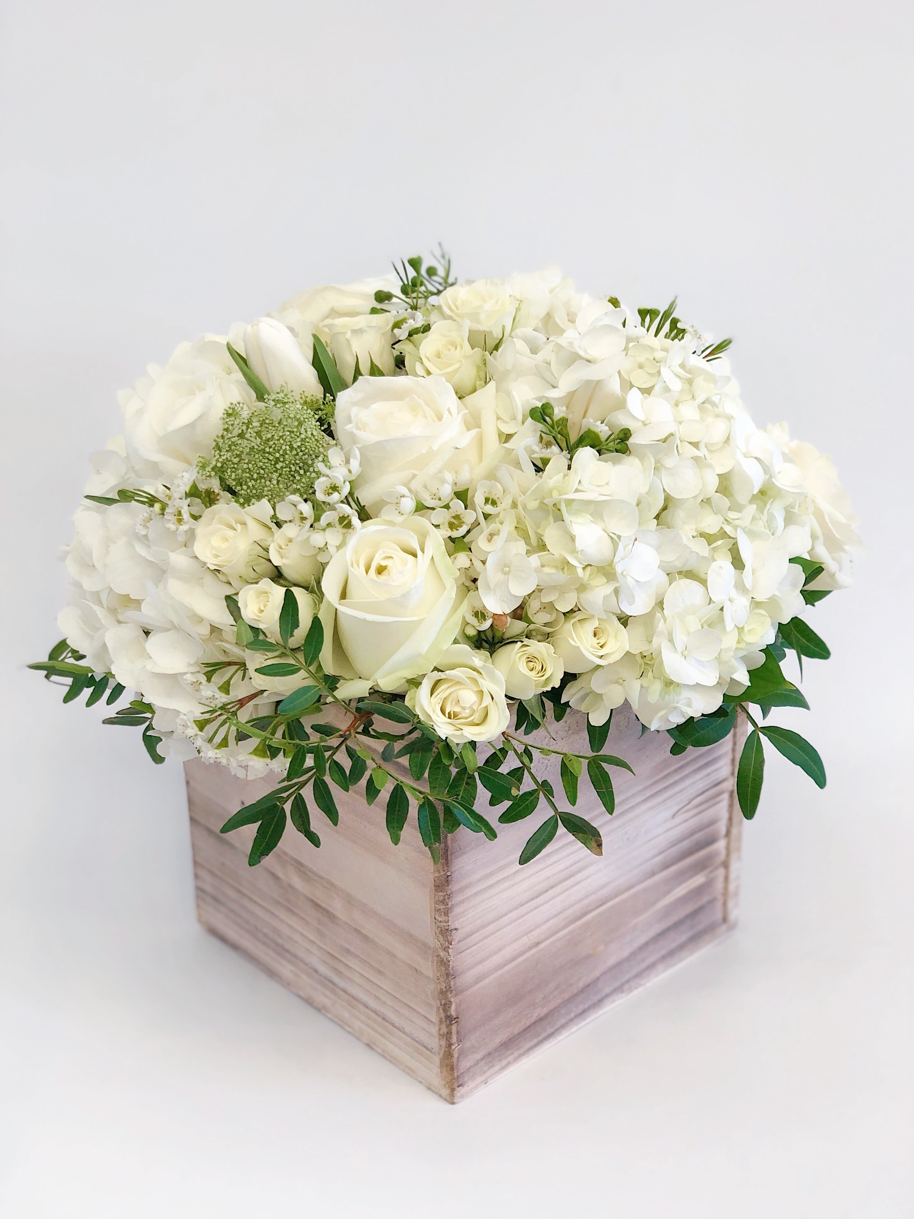 White roses and hydrangeas in a wooden box