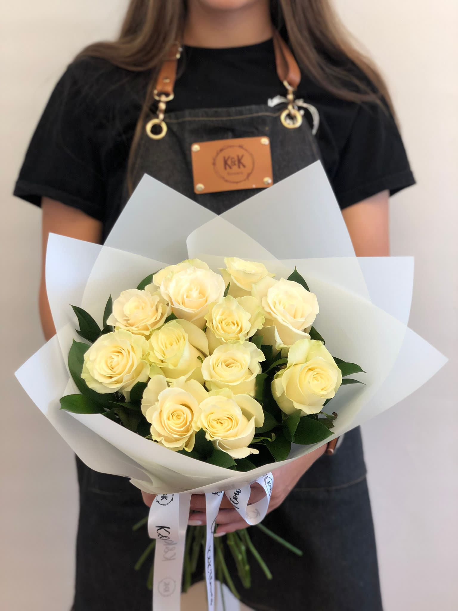 Bouquet of pale yellow roses wrapped in white paper