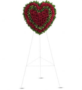 Heart-shaped standing floral wreath of red roses on an easel