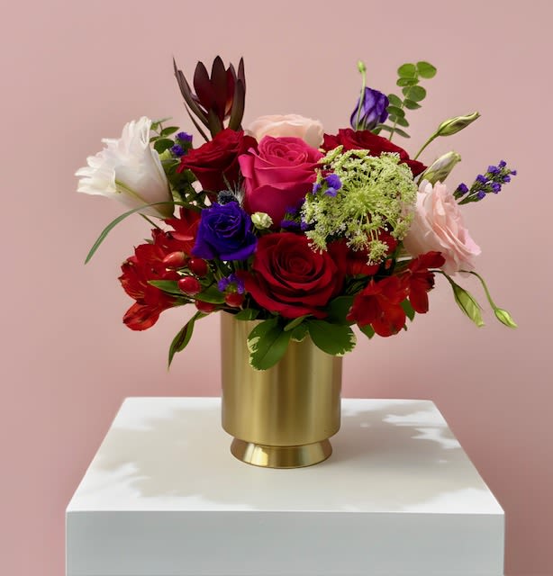 Mixed bouquet of roses and lilies in a gold vase