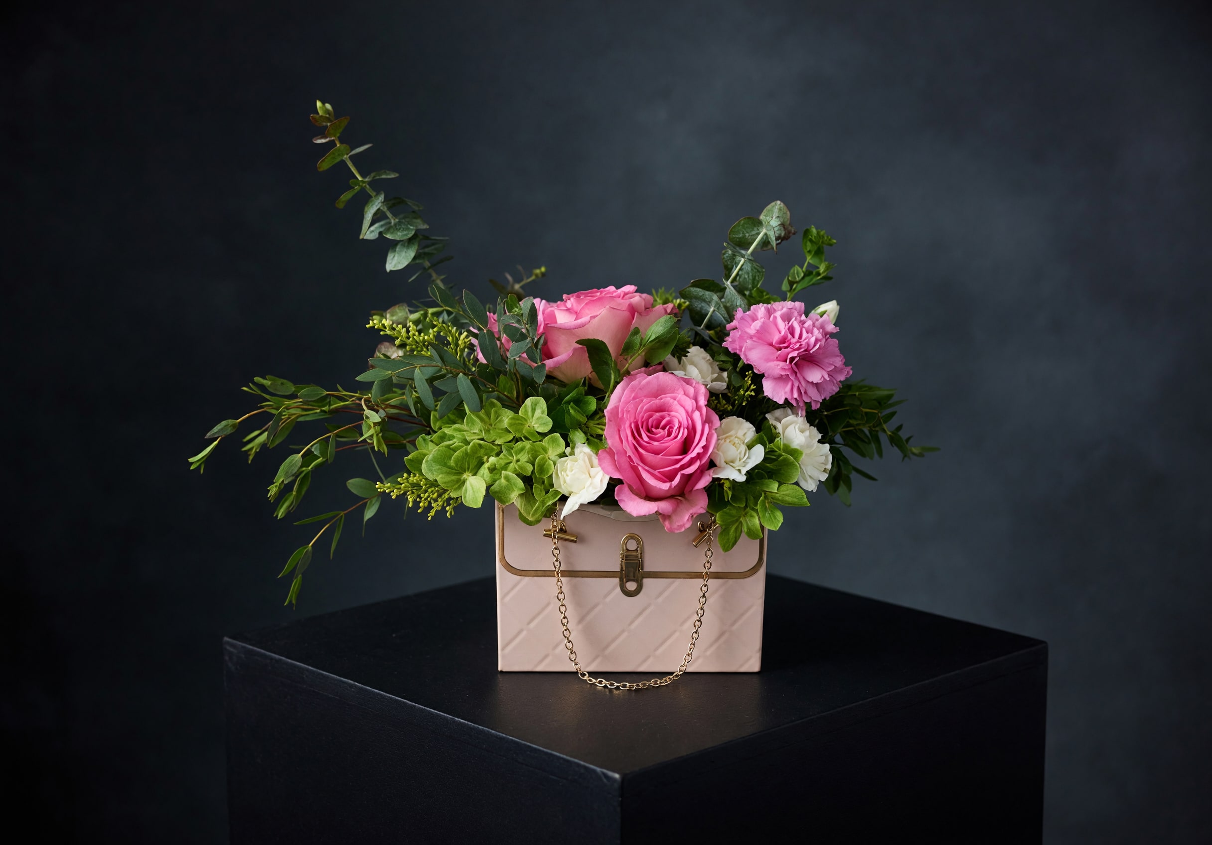  Luxe Bloom Bag - Our Luxe Bloom Bag features a fresh, garden-style mix of seasonal blooms and lush greenery arranged in a chic handbag-inspired container. Designed with a soft, airy feel, each piece is created to look effortless, elegant, and gift-ready for any occasion.  Perfect for Mother’s Day, birthdays, or simply showing someone they’re loved.  Because of the natural, loose design style, each arrangement will vary slightly — ensuring every piece is unique while maintaining the overall look and feel.  Available in blush or black. Limited quantities available. Pre-order recommended.