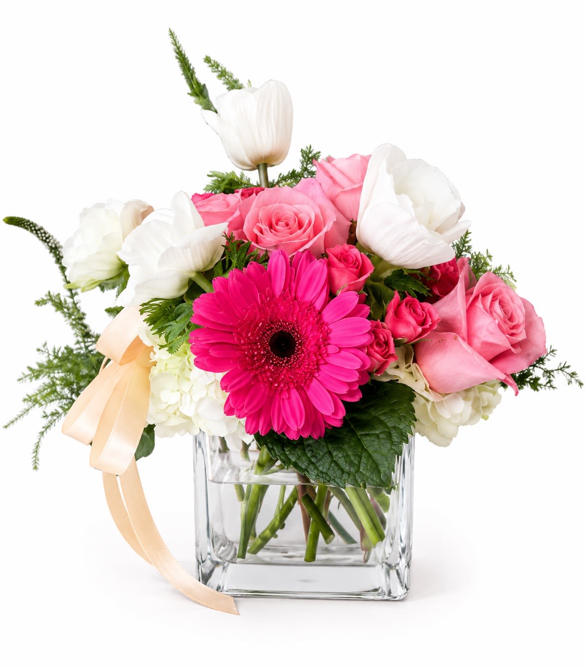 Petals and Pearls  - Bright, cheerful, and a little bit flirty - Petals and Pearls is a pink-and-white flower arrangement made to make someone feel genuinely celebrated. Perfect as a birthday bouquet, anniversary flowers, or a springtime surprise for the person you're thinking of, this rounded arrangement centers a vivid pink gerbera daisy that pops against soft pink roses and crisp white blooms for an immediate "wow" moment.  The composition mixes pink roses, a single vivid pink gerbera, white roses, white hydrangea, and white tulips, arranged full and rounded in a clear square glass vase so the stems and fresh water are part of the look. A peach satin ribbon ties around the vase for a gentle, elegant accent that complements the palette of pink, white, and touch of green foliage.  She'll feel seen and celebrated when this arrives - playful yet romantic, suitable for birthdays, anniversaries, or simply because. The vase size and visible stems give a classic florist finish; place in a cool spot away from direct sun and refresh the water every couple of days to keep blooms perky.
