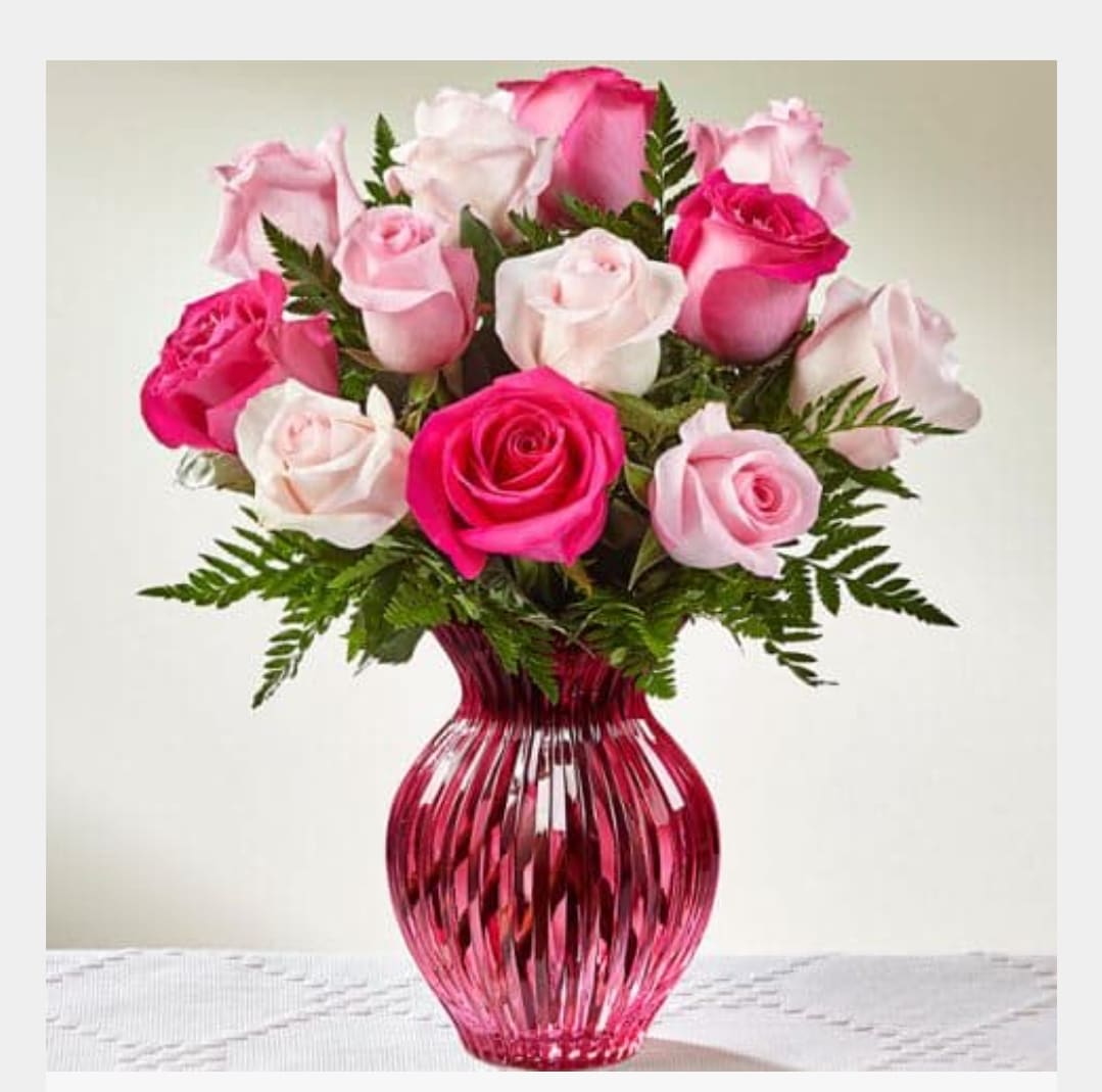 Pink and white roses in a red glass vase