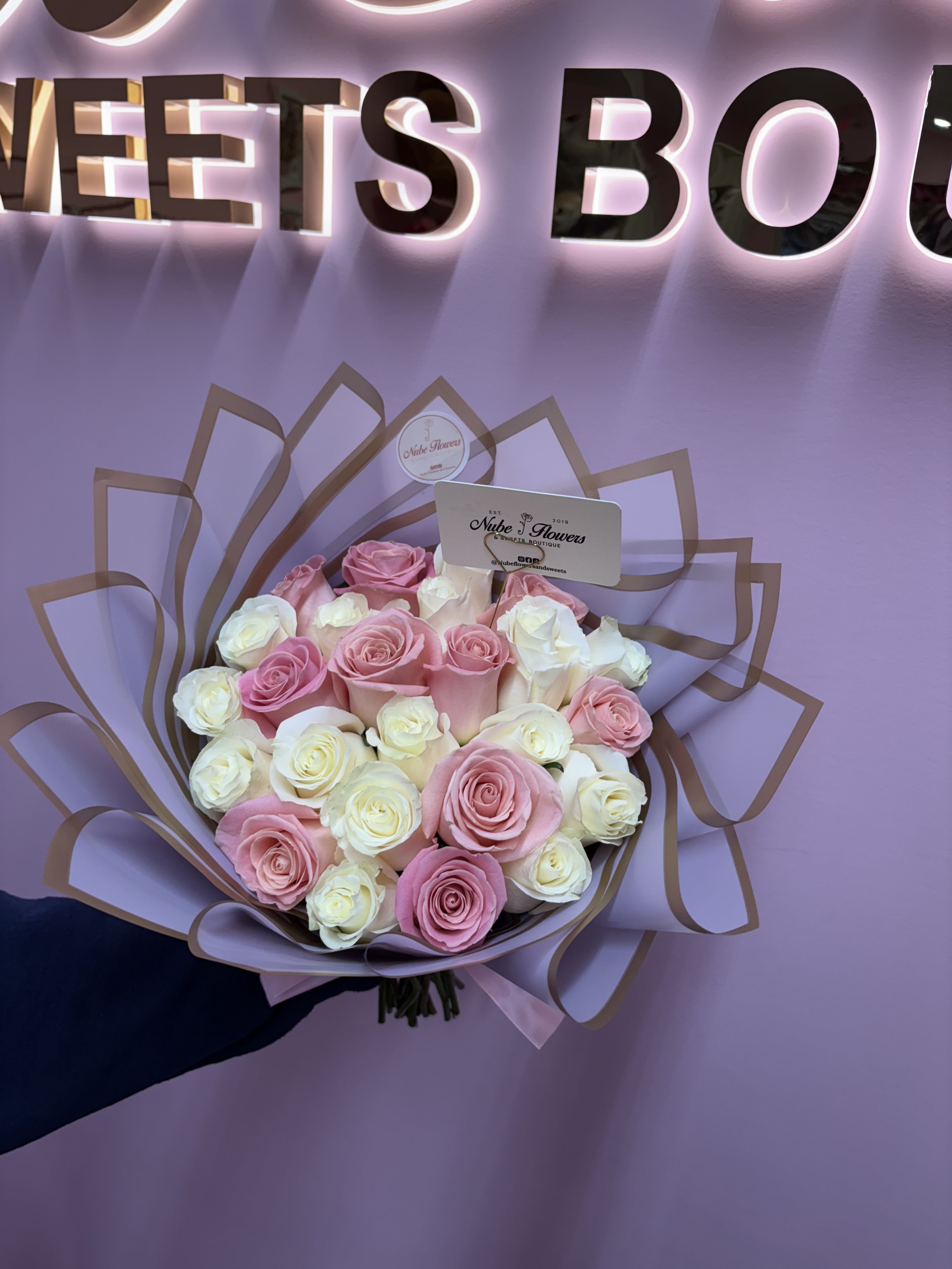 Bouquet of pink and white roses wrapped in lilac paper