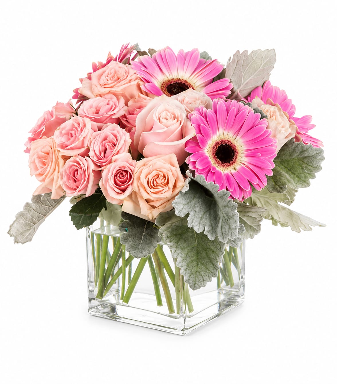 Main Squeeze - Peach and blush roses cuddle up to bright pink gerbera daisies in a compact, full-headed arrangement-an instant warm hug for an anniversary, birthday, or just because. This flower arrangement reads playful and polished: soft pastels and vivid daisy centers combine with pale silver‑green foliage to make the person you're sending it to feel genuinely seen and celebrated.  Tightly packed daisies, gerbera daisies, roses, and spray roses sit in a clear square glass vase for a clean, modern look that's easy to place on a bedside table or office desk. The palette of pink, white, peach, and green gives a fresh, feminine feel that works beautifully for new baby congratulations, thinking-of-you moments, get well wishes, or spring celebrations.  Thoughtful and low‑maintenance, this compact bouquet measures about 12" diameter by 10" high and arrives gift-ready-perfect for saying "congrats," "welcome," or "I love you" without fuss. Keep in fresh water and a cool spot out of direct sun to extend the cheer.