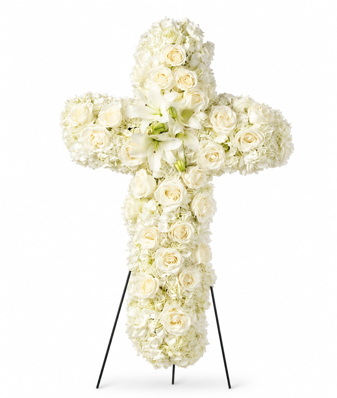 Eternal Grace - A serene white floral cross that reads as a quiet, reverent tribute-designed for sympathy and funeral services to honor the person you're remembering. The large cross shape mounted on a metal easel stand presents a formal, upright memorial that will make the recipient feel seen and respected during a difficult moment.  Tightly clustered white roses and hydrangeas form a soft, continuous surface, punctuated by a few lilies whose graceful petals add light, sculptural contrast. The unified white-and-green palette keeps the presentation calm and solemn while the dense, symmetrical design gives the piece a substantial, lasting presence at a service. The metal easel provides stable support and a clean silhouette so the cross reads clearly from across the room.  Perfect for memorial services, graveside ceremonies, or as a comforting display at a celebration of life, this arrangement conveys sympathy and dignity without words. Available in a large, service-ready size on an easel; no special care is needed once displayed-our team prepares and secures the flowers so it arrives ready for placement.