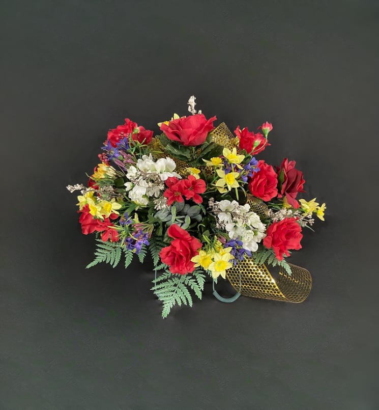Colorful bouquet of red, white, yellow, and purple flowers with gold ribbon