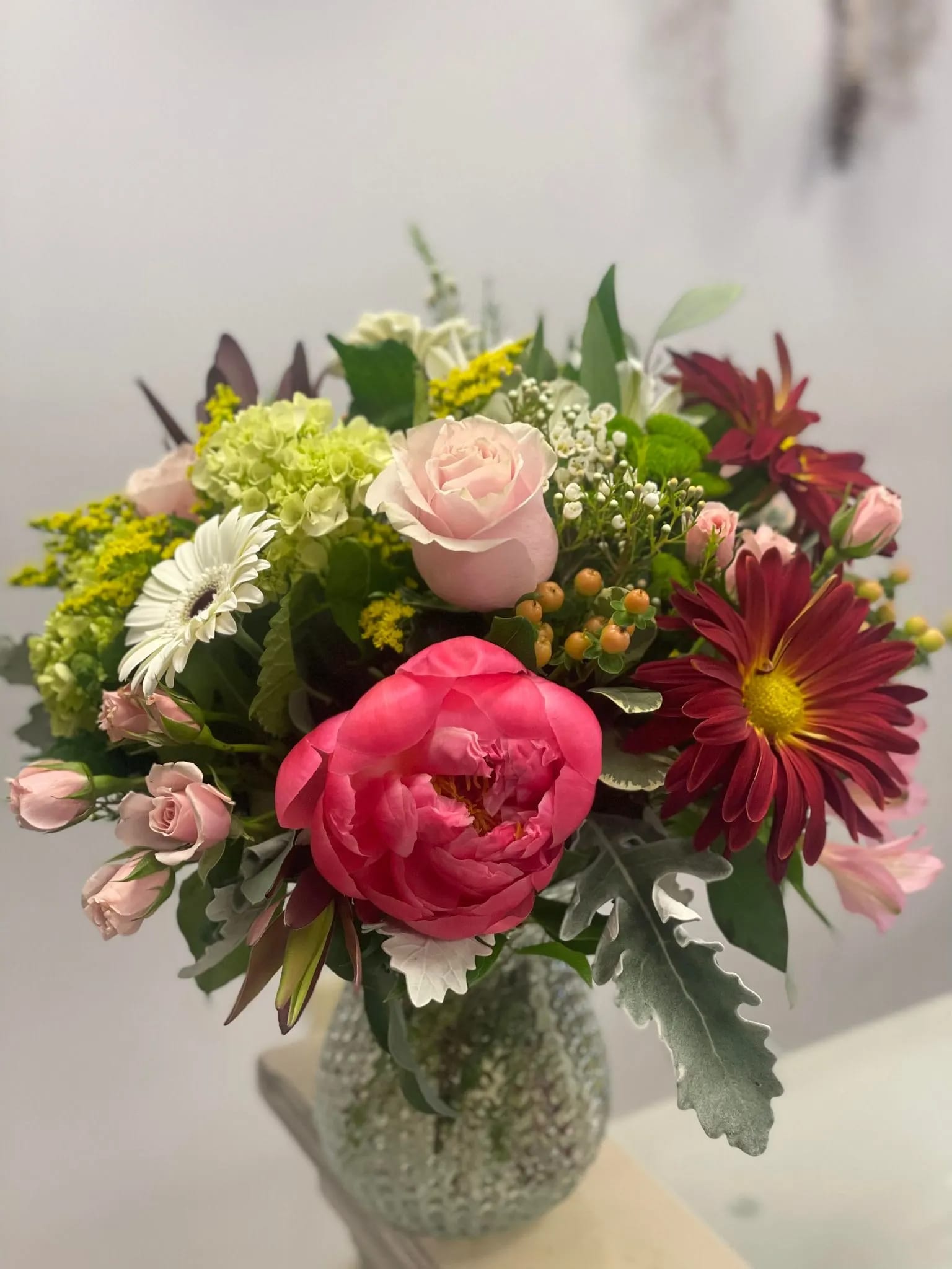 The Star of the Show -  This carefully curated arrangement features the timeless beauty of coral peonies harmoniously blended with a symphony of seasonal blooms, creating a visual masterpiece that captures the essence of the fall season.