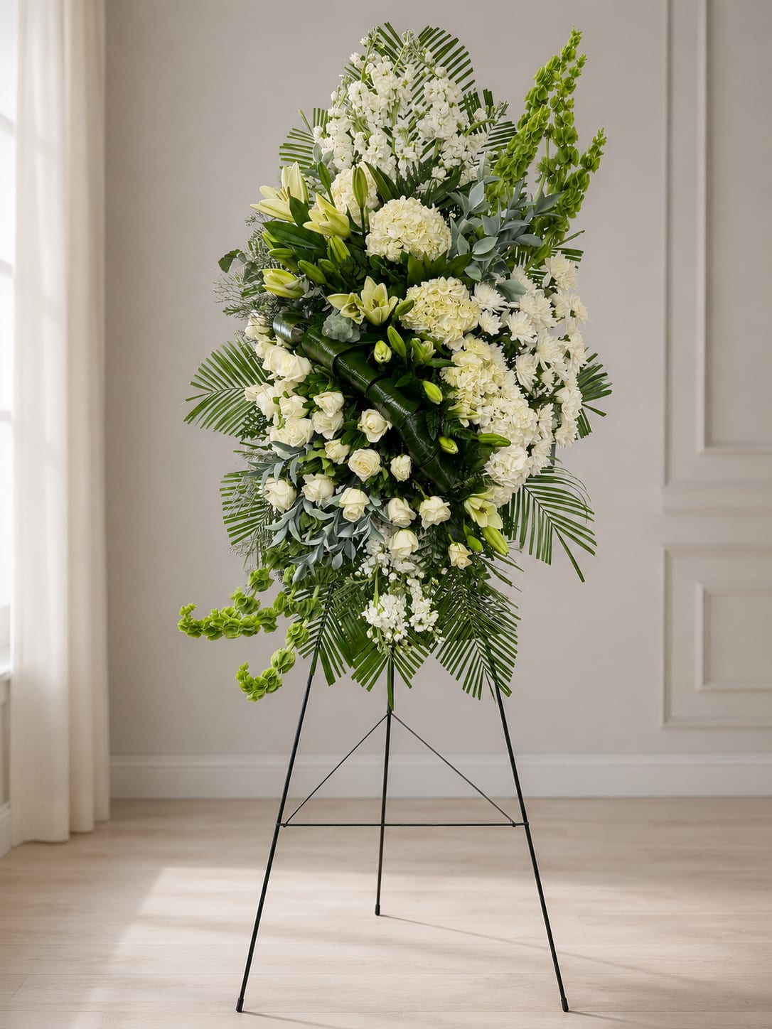 Emerald Grace Standing Sympathy Spray - The Emerald Grace Standing Sympathy Spray is a stunning 92-inch tall(7.5 FEET) funeral easel arrangement designed with elegant white roses, hydrangeas, lilies, lush greenery, and fresh green Bells of Ireland. This large standing spray creates a graceful and memorable tribute for funerals, memorial services, and celebration of life ceremonies. A beautiful choice for expressing sympathy with elegance and peace.