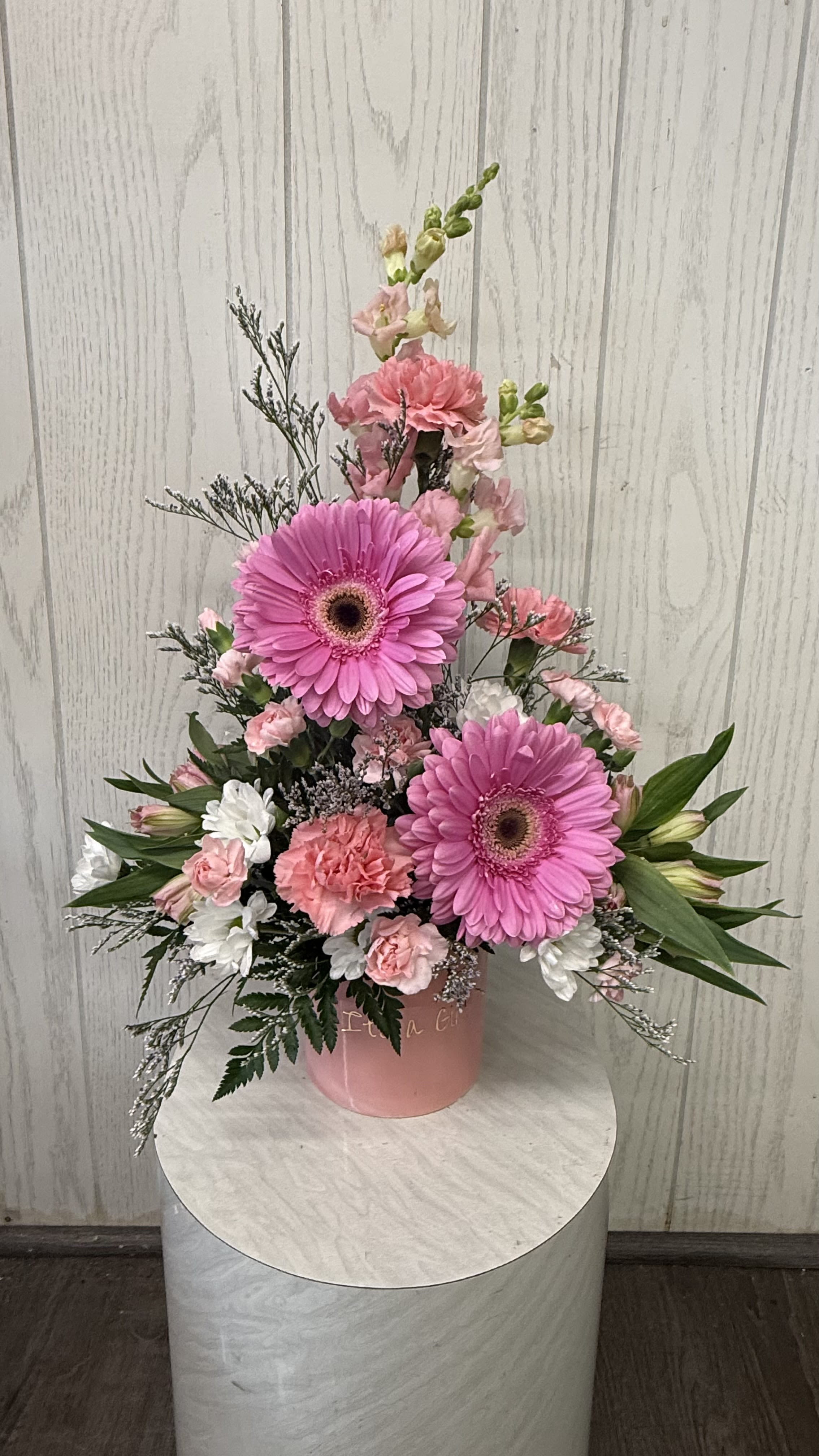 It's a Girl Arrangement - Celebrate the birth of a baby girl with this "it's a girl" themed container, complemented with beautiful flowers to mark the special occasion.  This is a one sidedd arrangement. Deluxe &amp; premium include more flowers. Substitutions are possible based on the current floral inventory. The overall look and feel will be maintained. 