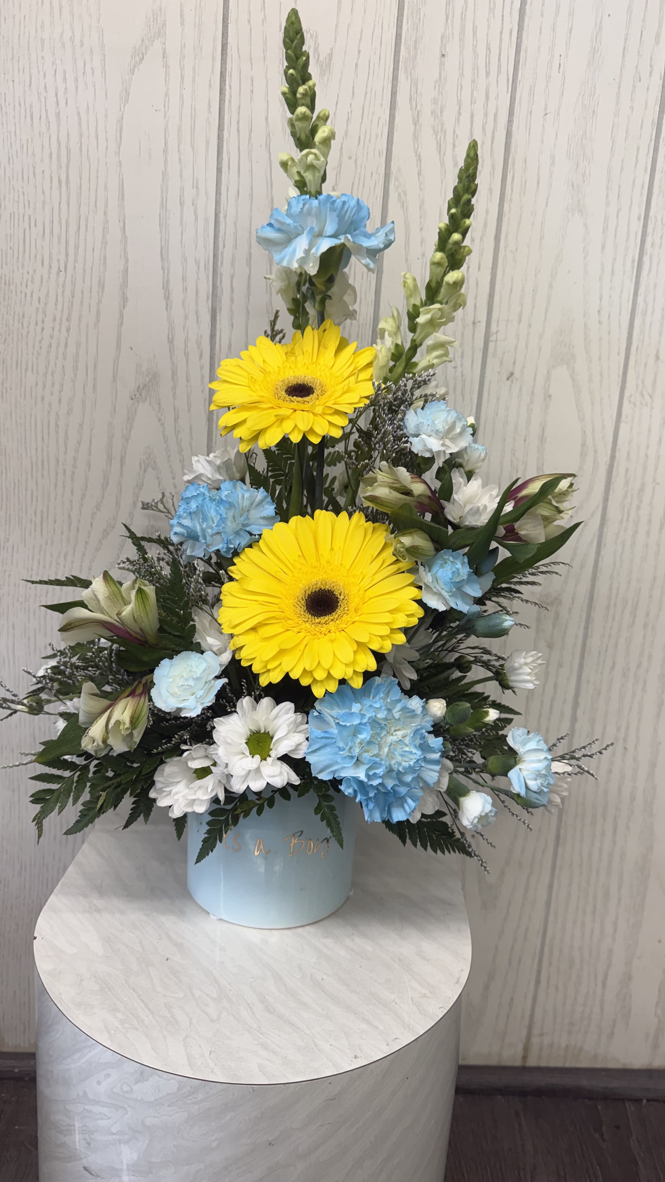 It's a Boy arrangement - Celebrate the birth of a baby boyl with this "it's a boy" themed container, complemented with beautiful flowers to mark the special occasion.  This is a one sidedd arrangement. Deluxe &amp; premium include more flowers. Substitutions are possible based on the current floral inventory. The overall look and feel will be maintained. 